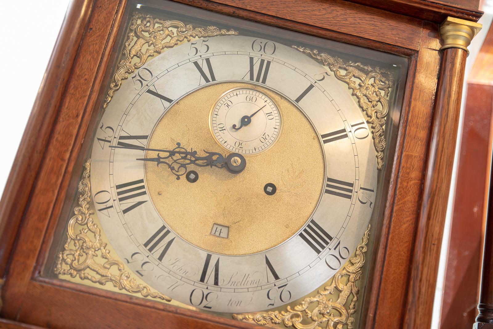 This lovely 8 day square brass dial strikes the hours on a single bell.
The maker is John Snelling of Alton in Hampshire and was recorded working from 1761 onwards.
This is very slim oak case with original caddy top and side viewing glass to the