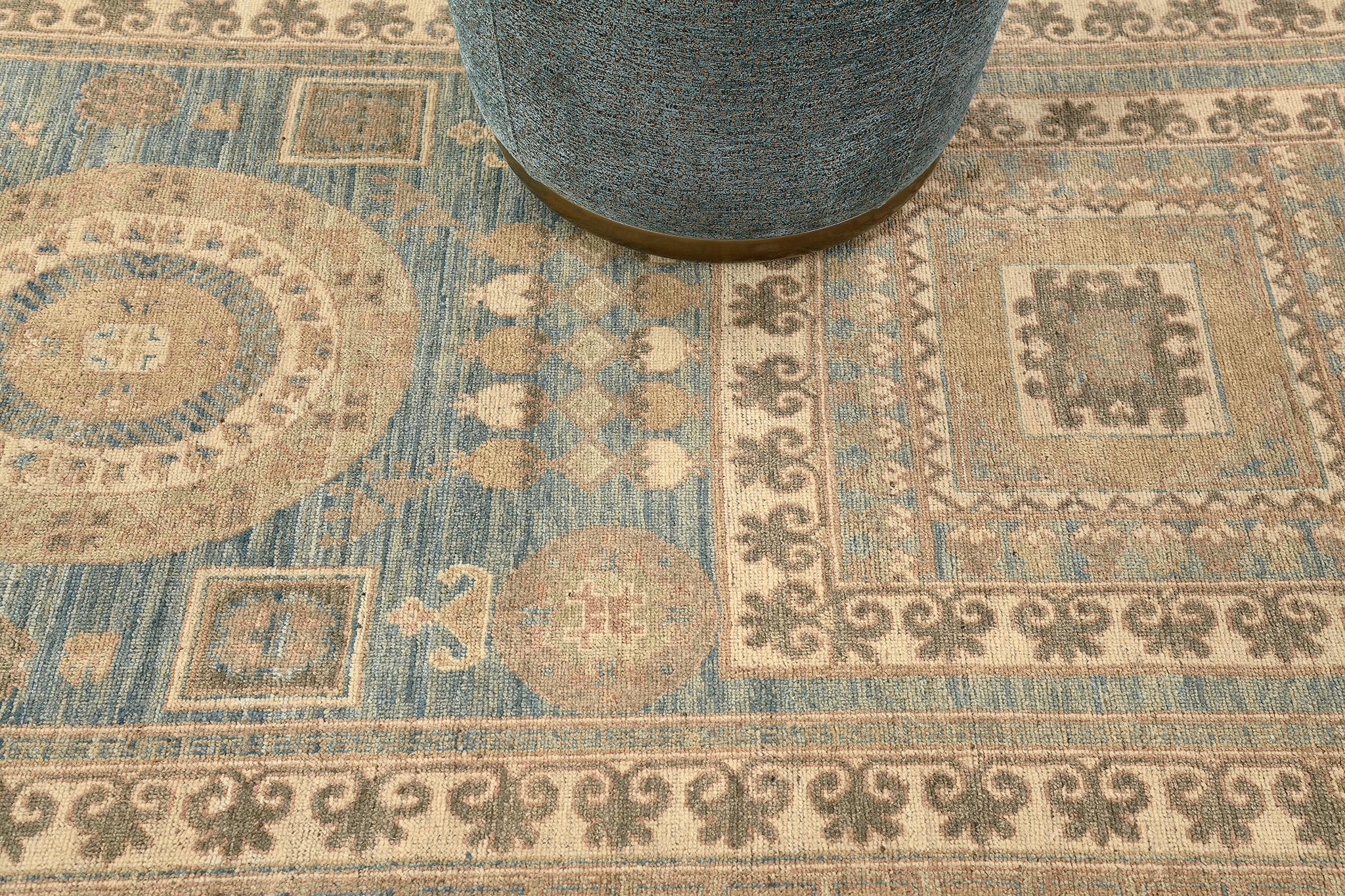Eine gut gestaltete Wiederbelebung eines Khotan-Design-Teppichs, die sich ideal für ein Wandstück zwischen Decke und Boden eignet. Symmetrische Motive sind aneinandergereiht, die in der Mitte Lücken aufweisen, die mit unterschiedlichen geometrischen