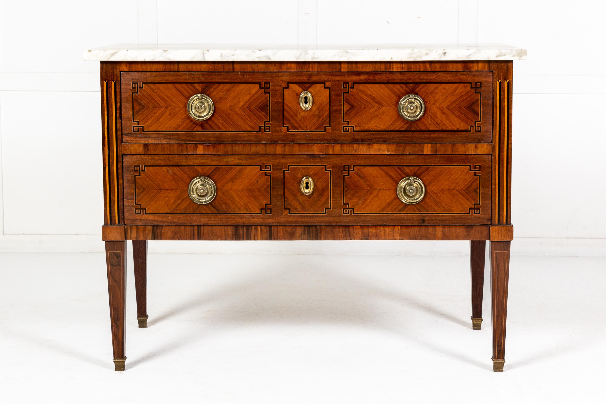 A handsome 18th century kingwood and walnut commode with a white and grey veined marble top, having two long drawers below with brass ring pull handles and escutcheons, decorated with inlay of ebony and satinwood, with matching inlay to the sides