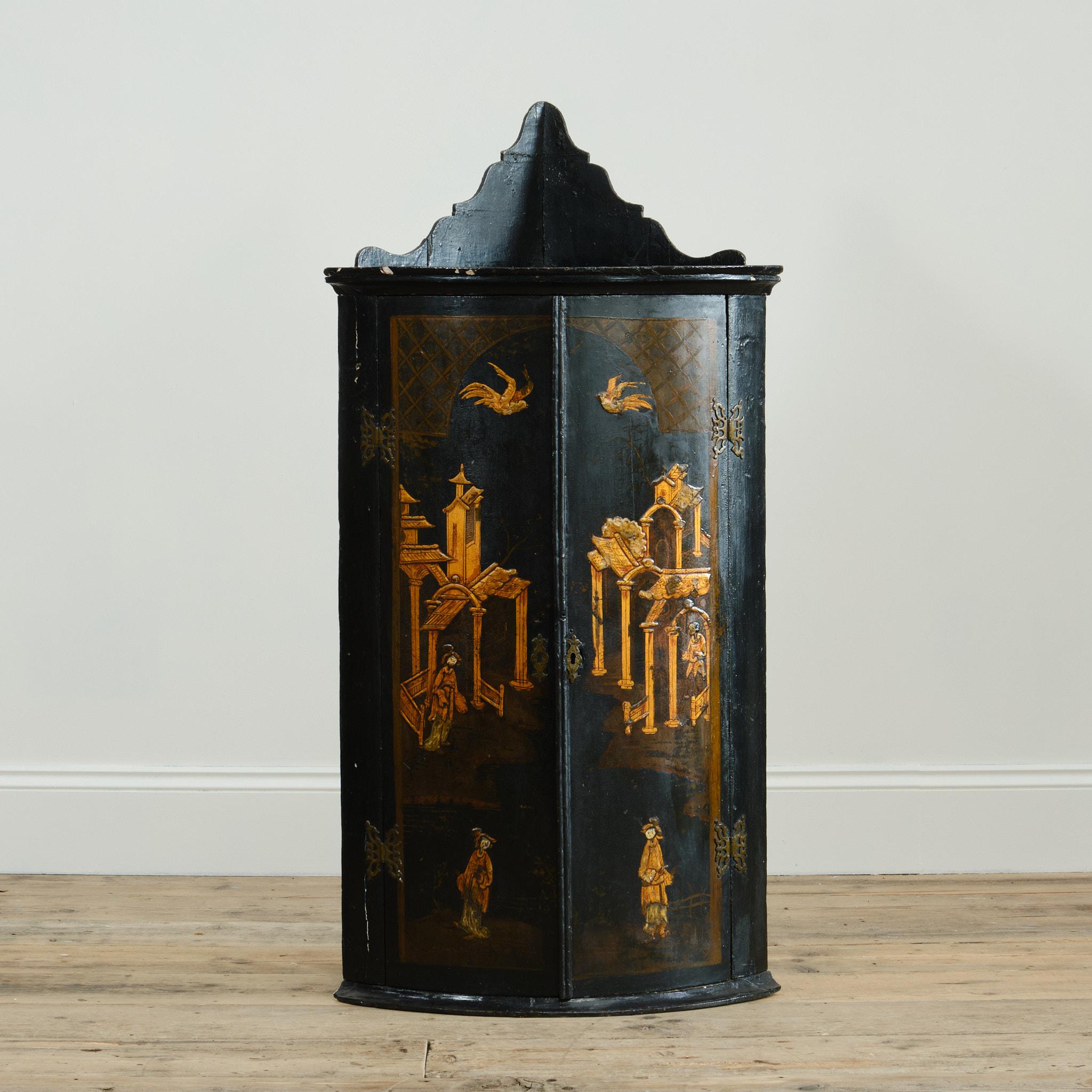 An 18th century lacquered bow front corner cupboard with raised Chinoiserie gilt decoration depicting traditional scenes below the shaped gallery. The inside painted in red with 3 shelves. Retaining its original butterfly hinges and escutcheons.