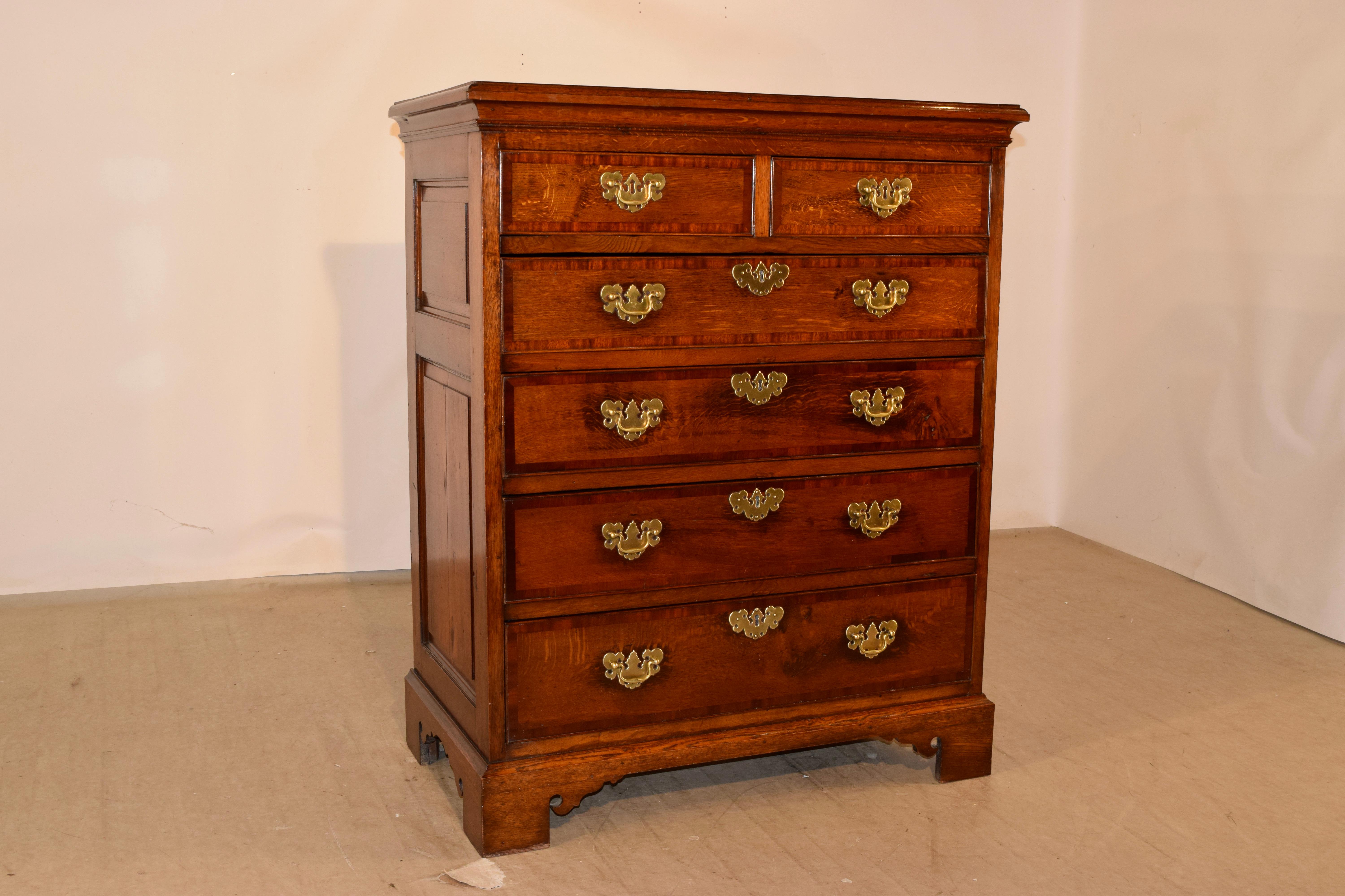 18th century oak and mahogany stunning chest of drawers from the Lancashire region of England. The top has a beveled edge and is banded in fine mahogany. This follows down to raised paneled sides and two over four drawers, all of the drawer fronts