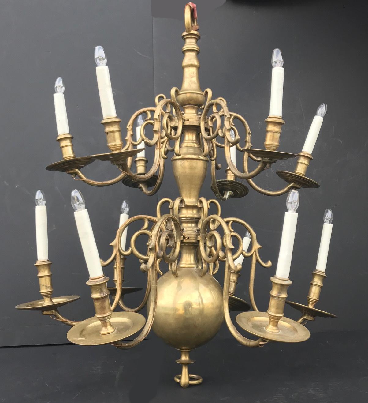 Dutch chandelier, large brass 18th century hanging lights, baroque, two-tiered, 12-light, good working condition.

This heavy antique chandelier is casted in solid brass. It has a well proportioned baluster stem and a large, massive centre sphere