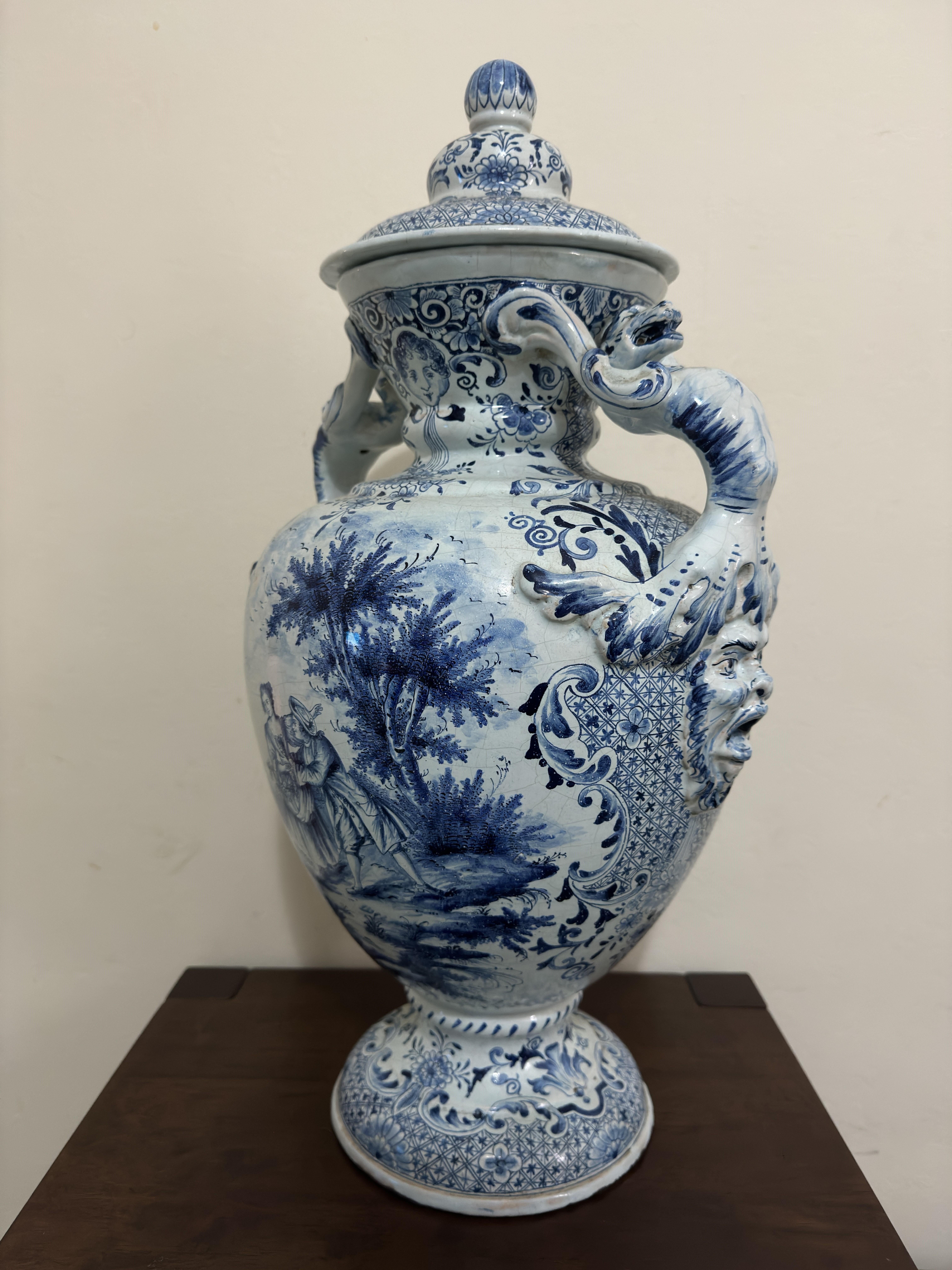 18th Century Large Delft Urn / Vase , with beast decorated handles, 
painted in blue with river landscapes, a courting couple and bridge, within foliate and leaf borders.  A good example of a Dutch Delft piece made in the 18th century with