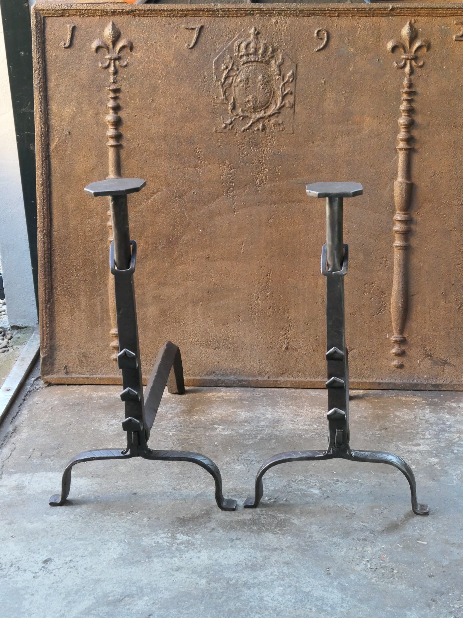 18th century French andirons - fire dogs made of wrought iron. These French andirons are called 'landiers' in France. This dates from the times the andirons were the main cooking equipment in the house. They had spit hooks to grill meat or poultry