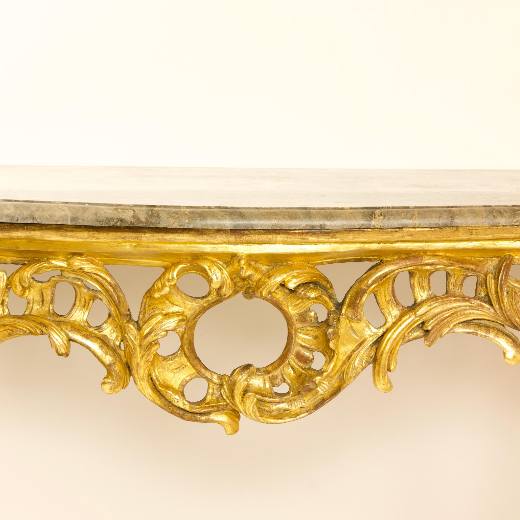 18th century large French Louis XV carved giltwood rocaille console table

A large mid 18th century Louis XV console table with a pierced frieze carved with rocaille and leaves, with a large central rocaille motif and stylised rose buds on each