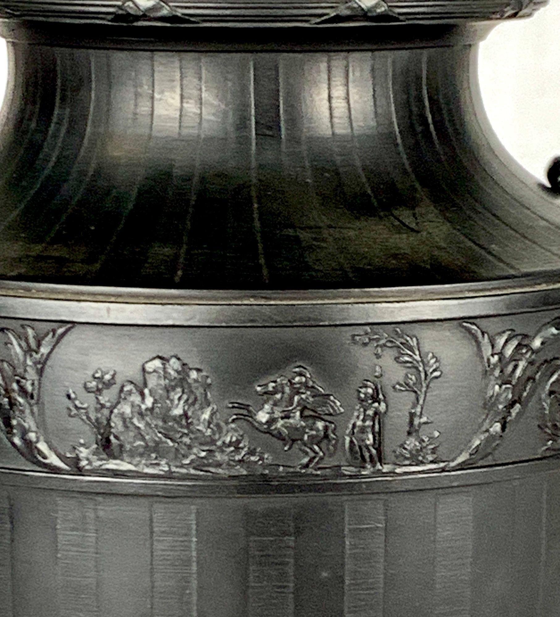 Questo imponente vaso in basalto nero, realizzato da Wedgwood & Bentley nella rinomata fabbrica Etruria, incarna la raffinata semplicità dello stile neoclassico.
Il vaso ha una forma ovoidale allungata che si assottiglia graziosamente fino a una