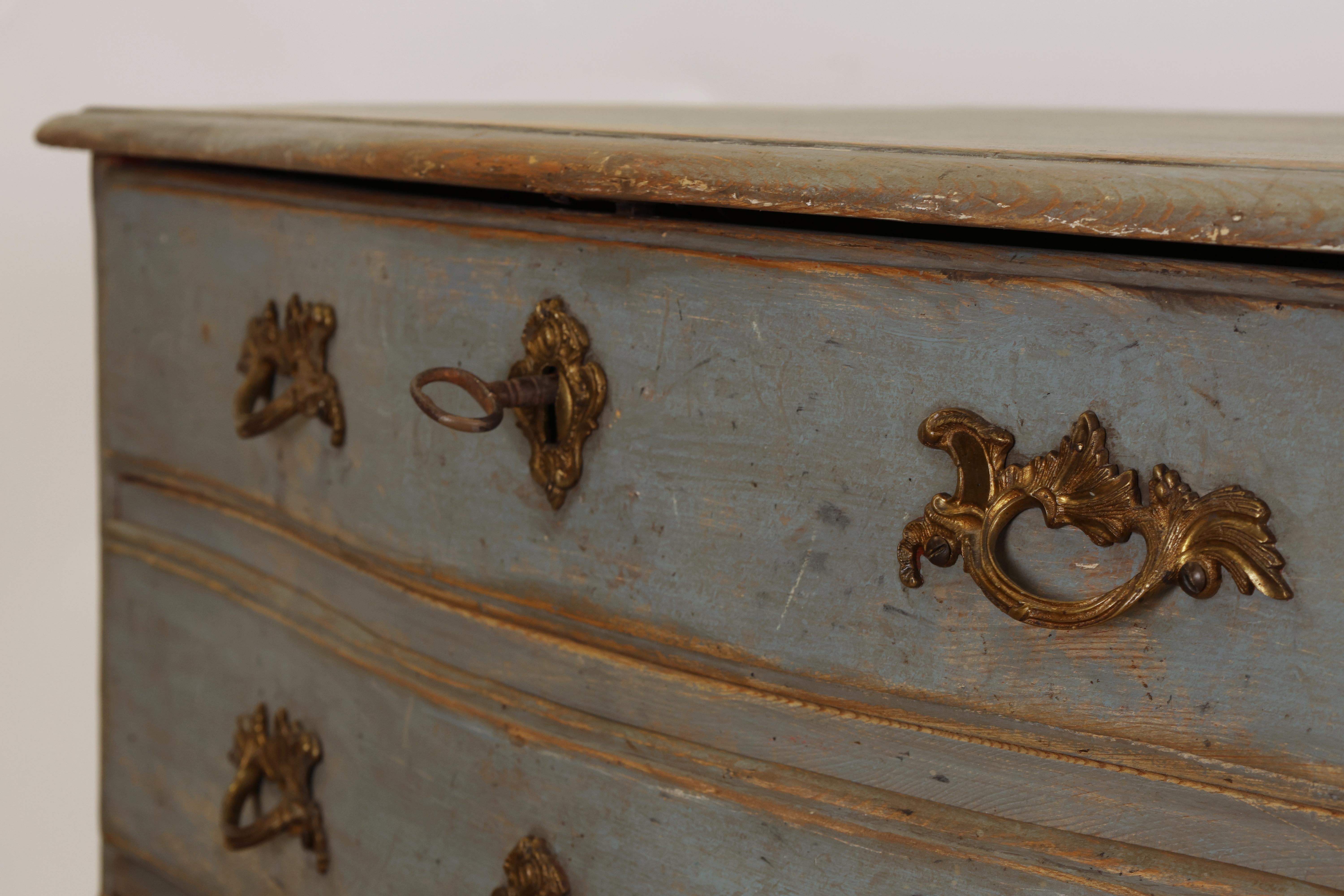 Swedish late Baroque chest of drawers from the mid-18th century. The chest features original locks and old gilded fittings. It has three drawers and a contoured lambrequin.