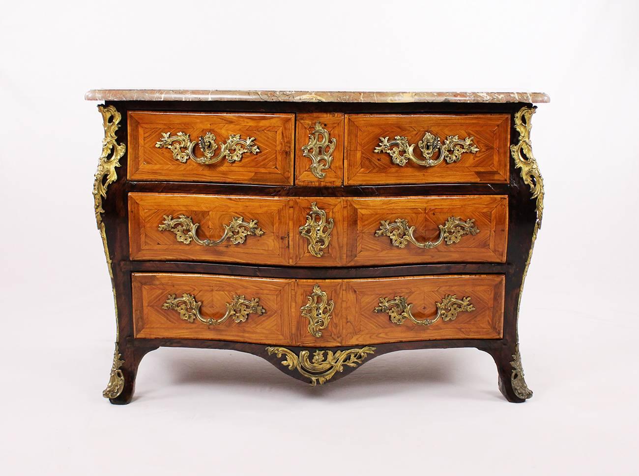 A stately chest of drawers from the late Baroque period from France, worked, circa 1750-1760 in rosewood, walnut and other fine woods. Finished with original reddish marble top, 4 drawers with original metal fittings. Belly corpus with molded edges,