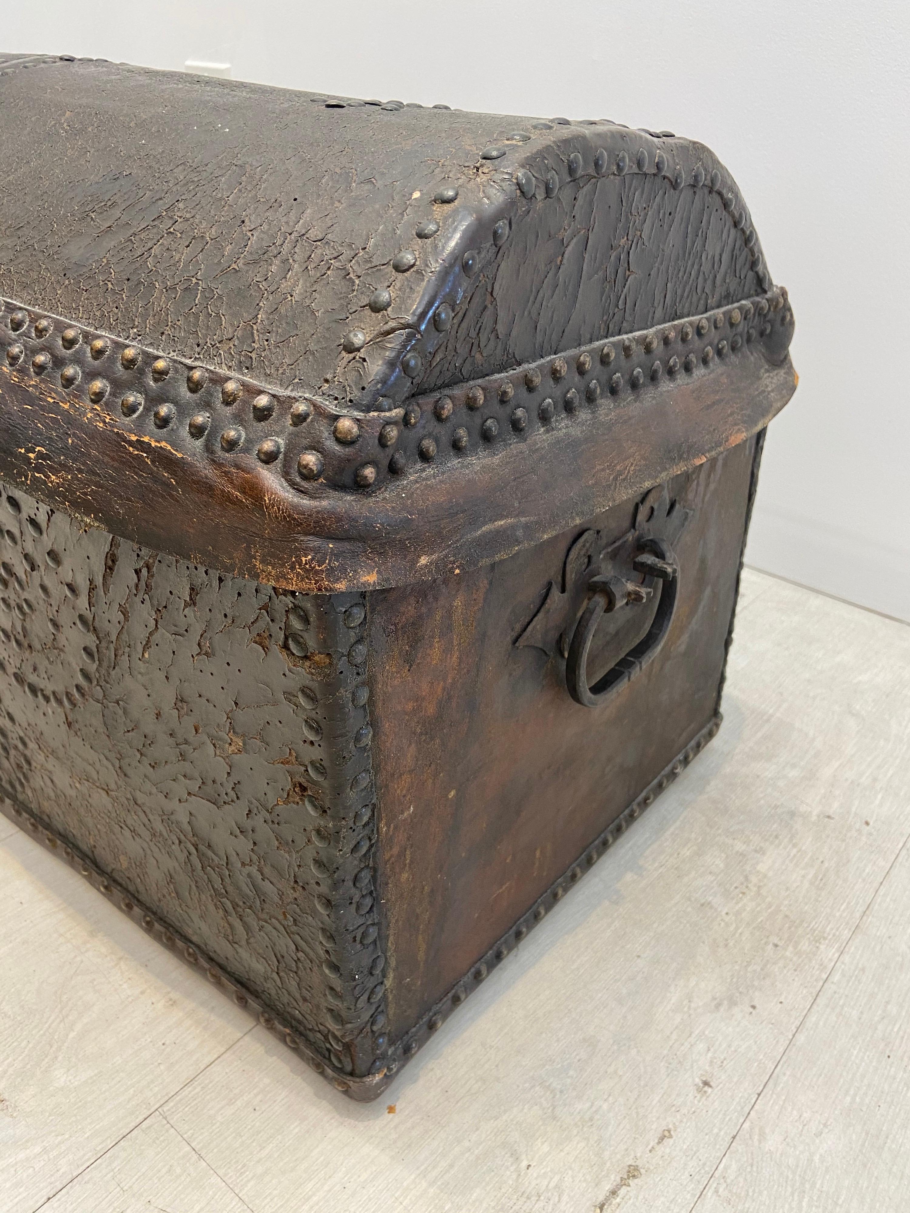 18th century leather dome top trunk in good condition… With brass nail heads and brass bail pulls at the sides… The front lock does not work but the back plate as well as the strap hinges are all original… Interior has been lined with linen… Part of