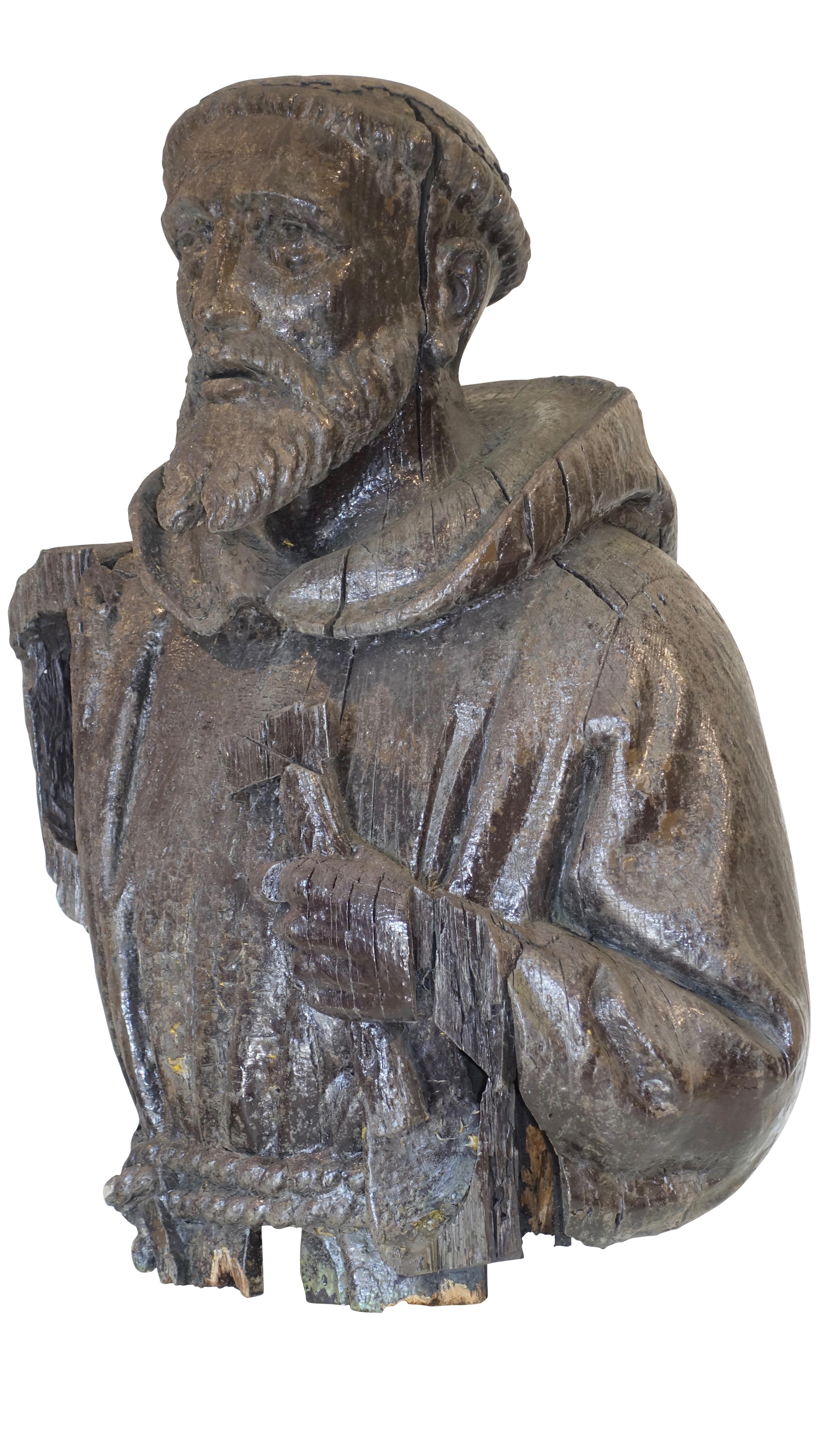An impressive large scale hand carved wooden religious bust and torso of Saint Francis. Fragmented figure with weathered black paint over pine. Continental, (possibly Spanish), very early 18th century.
 