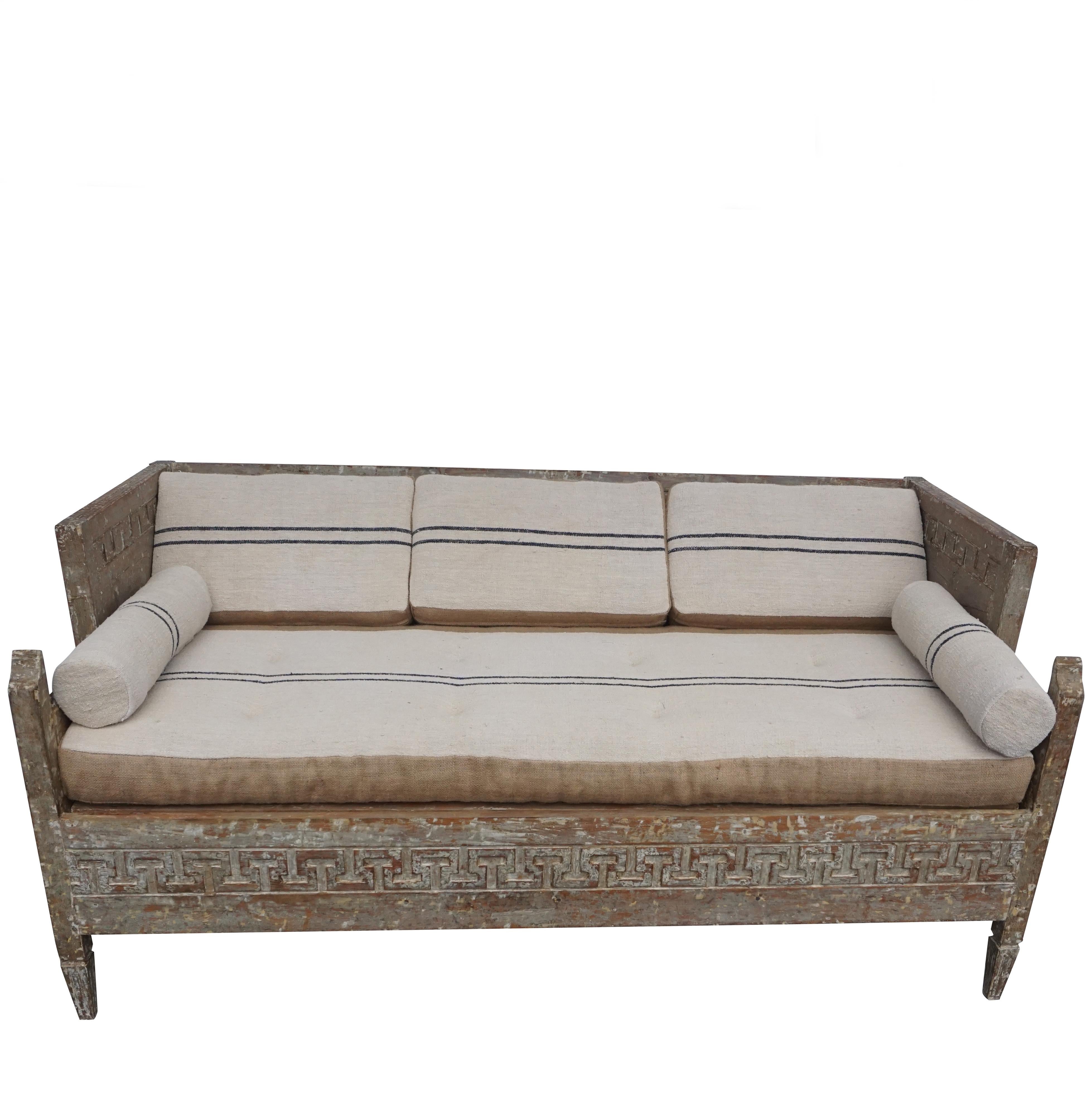 An antique Lit Du Jour, Swedish Gustavian daybed made of hand carved pinewood and fabric. This charming wood sofa was scraped to its original finish. Hand carved Greek key ornaments with an expandable storage space below sitting area, in good
