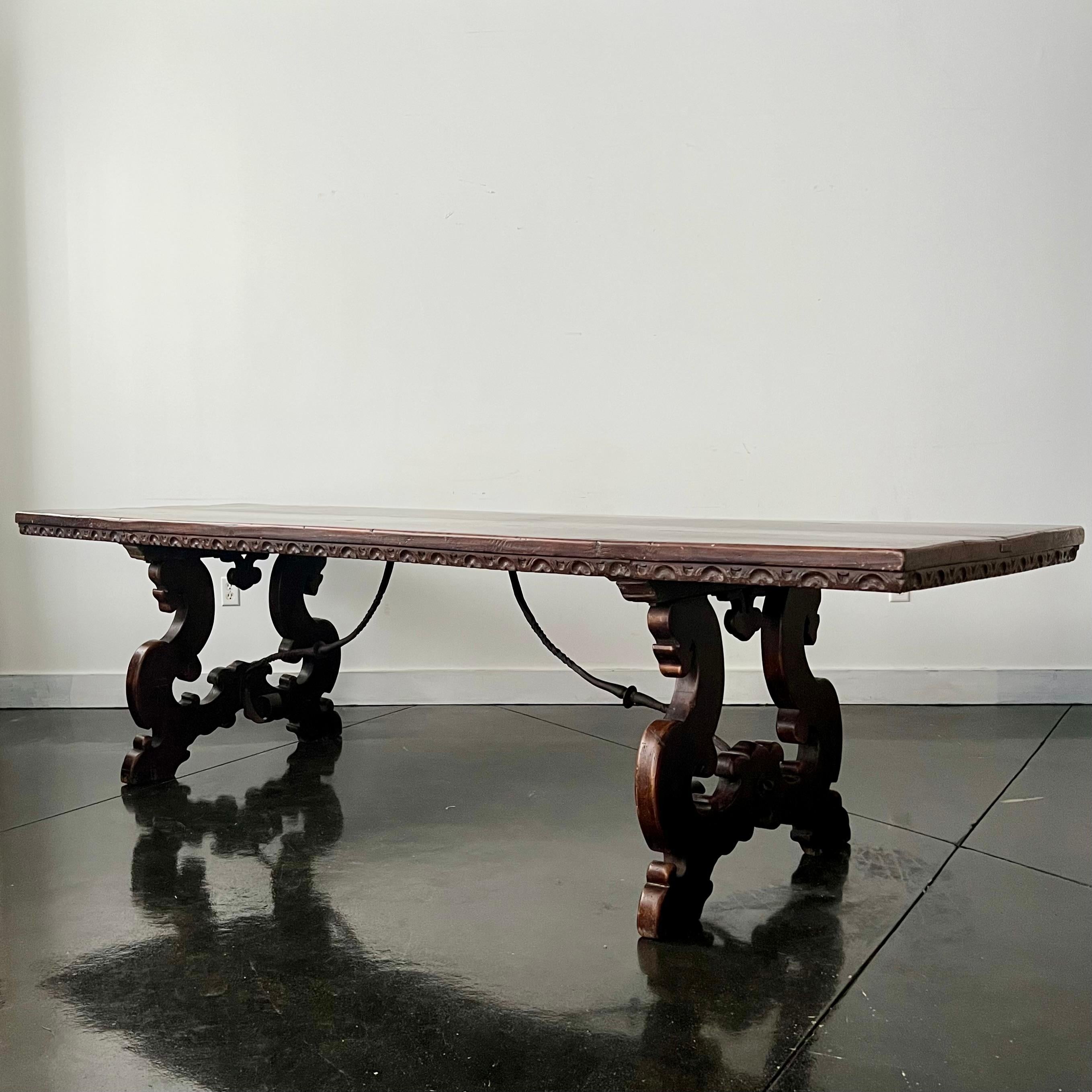 Super long 18th century, Florentine Italian walnut dining table with Lyre legs, hand forged iron stretcher base topped with carved edge, long thick walnut top in rich brown patina.
Florence, Italy, 18th century
