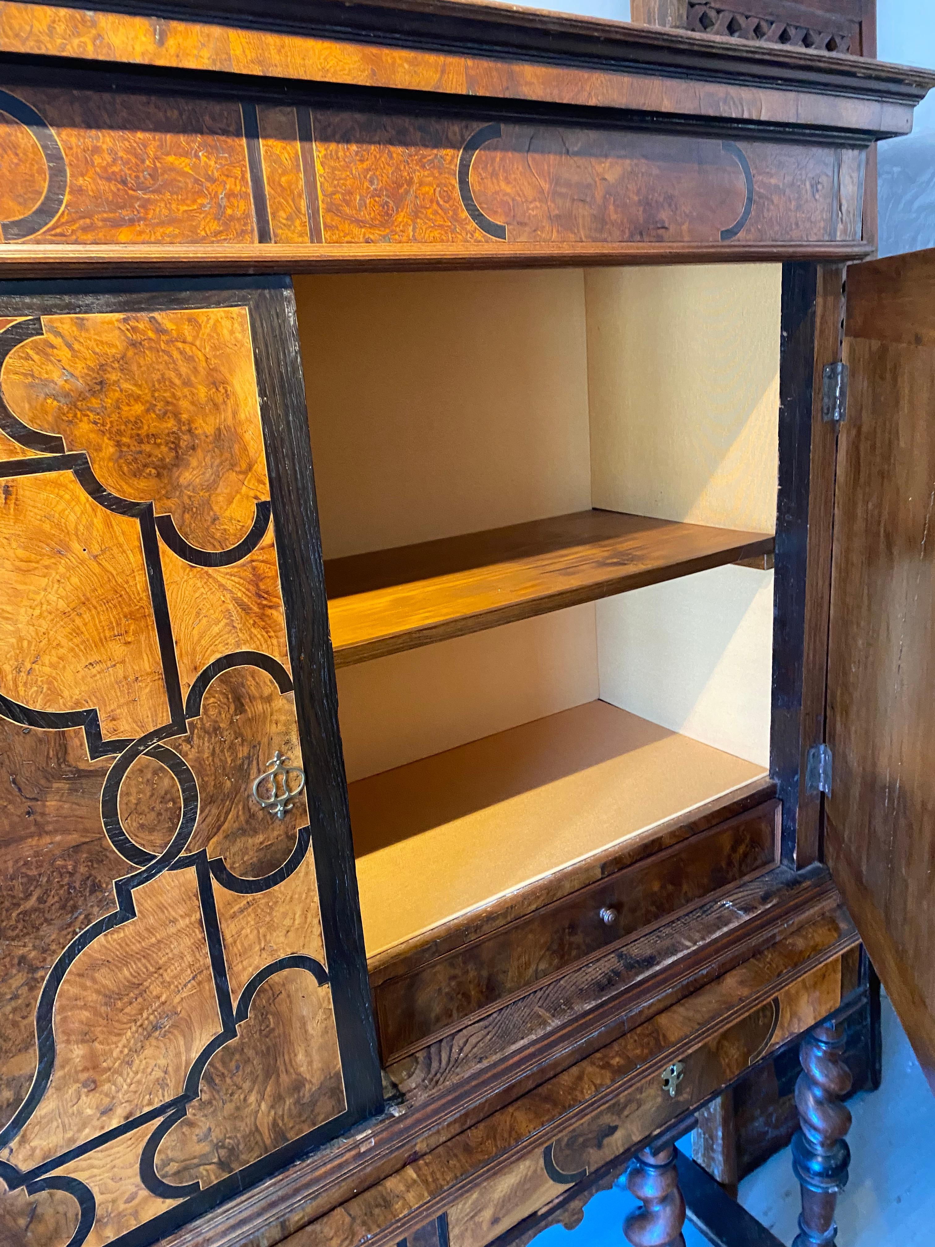 Made of walnut and burl walnut decorated with geometric inlay pattern ,it open with two leaves and two drawers in the front resting on twisted turned wooden legs joined by a spacer . Inside is covered with fabric and there is also two drawers.With a