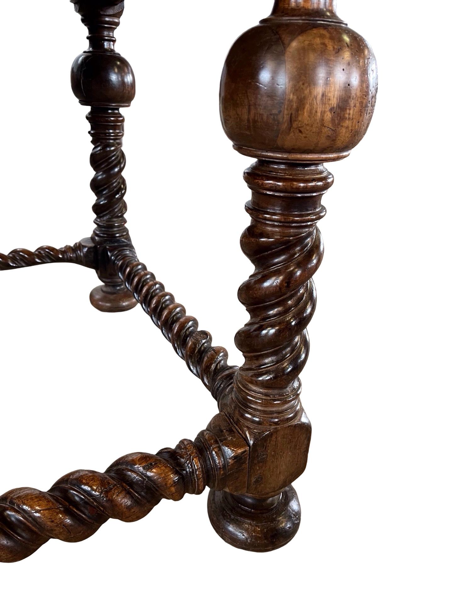 Mesa auxiliar / centro de mesa Luis XIII fabricada a mano en Francia a principios del siglo XVIII con madera de nogal y clavijas. La mesa tiene unas proporciones magníficas y presenta un tablero de tres tablas con bordes conopiales. El faldón es
