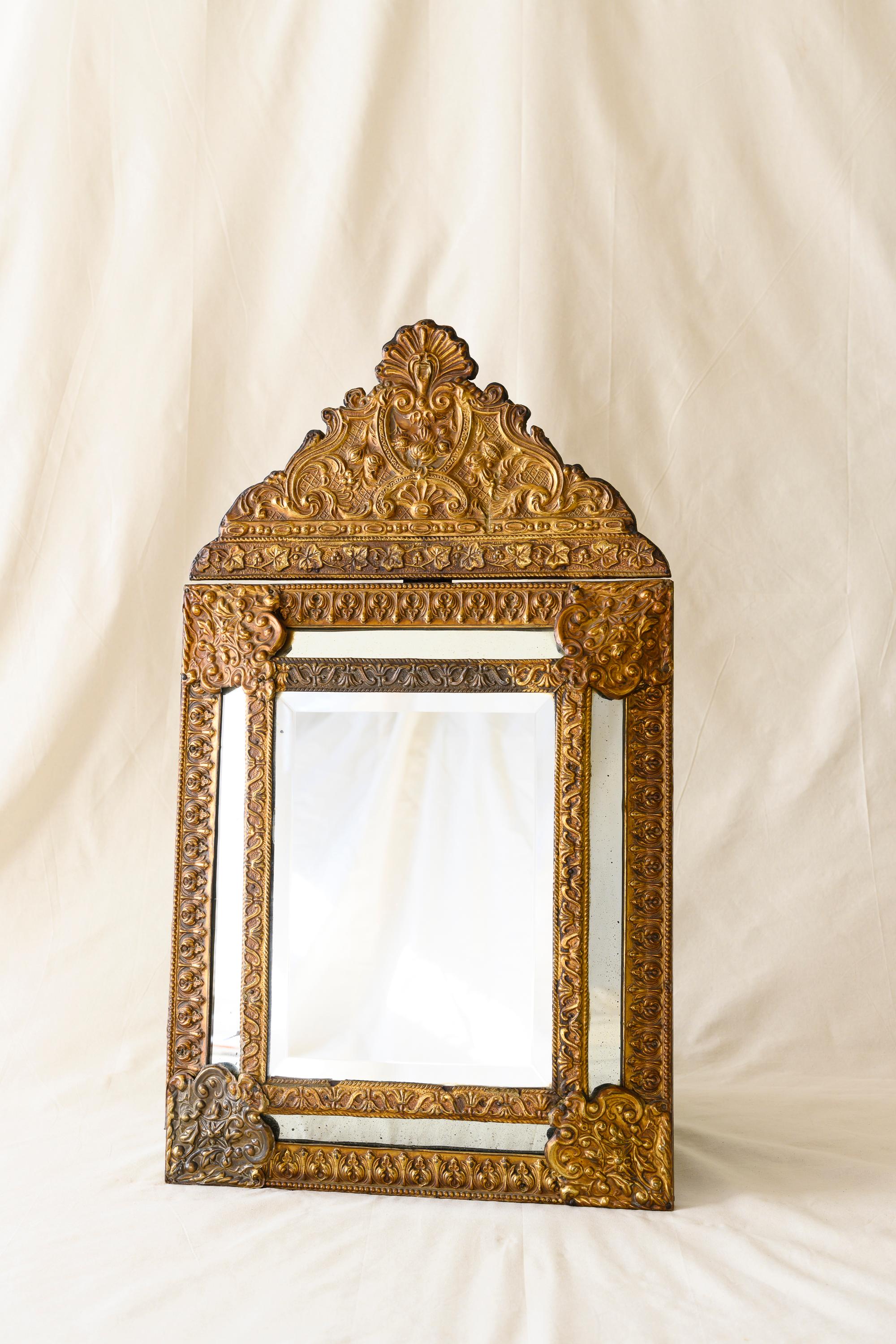 Louis XIII style gilt-copper and wood mirror, featuring an elevated rectangular mercury glass plate in an intricate foliage and scroll frame with mirrored borders, topped by a detachable crest of scrolled foliage and a frieze of berried grape