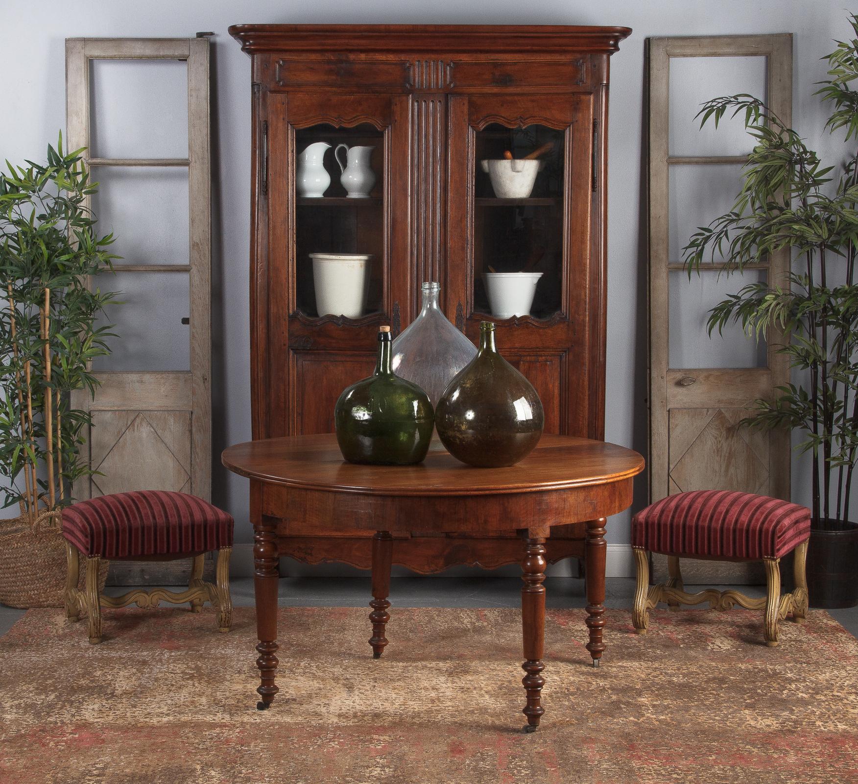 A stunning 18th century armoire that combines the Louis XIV and the Louis XV styles. Purchased in the Rhone Valley, the armoire is made of solid dark walnut with a gorgeous patina. The top parts of the paneled doors were later changes to glass to