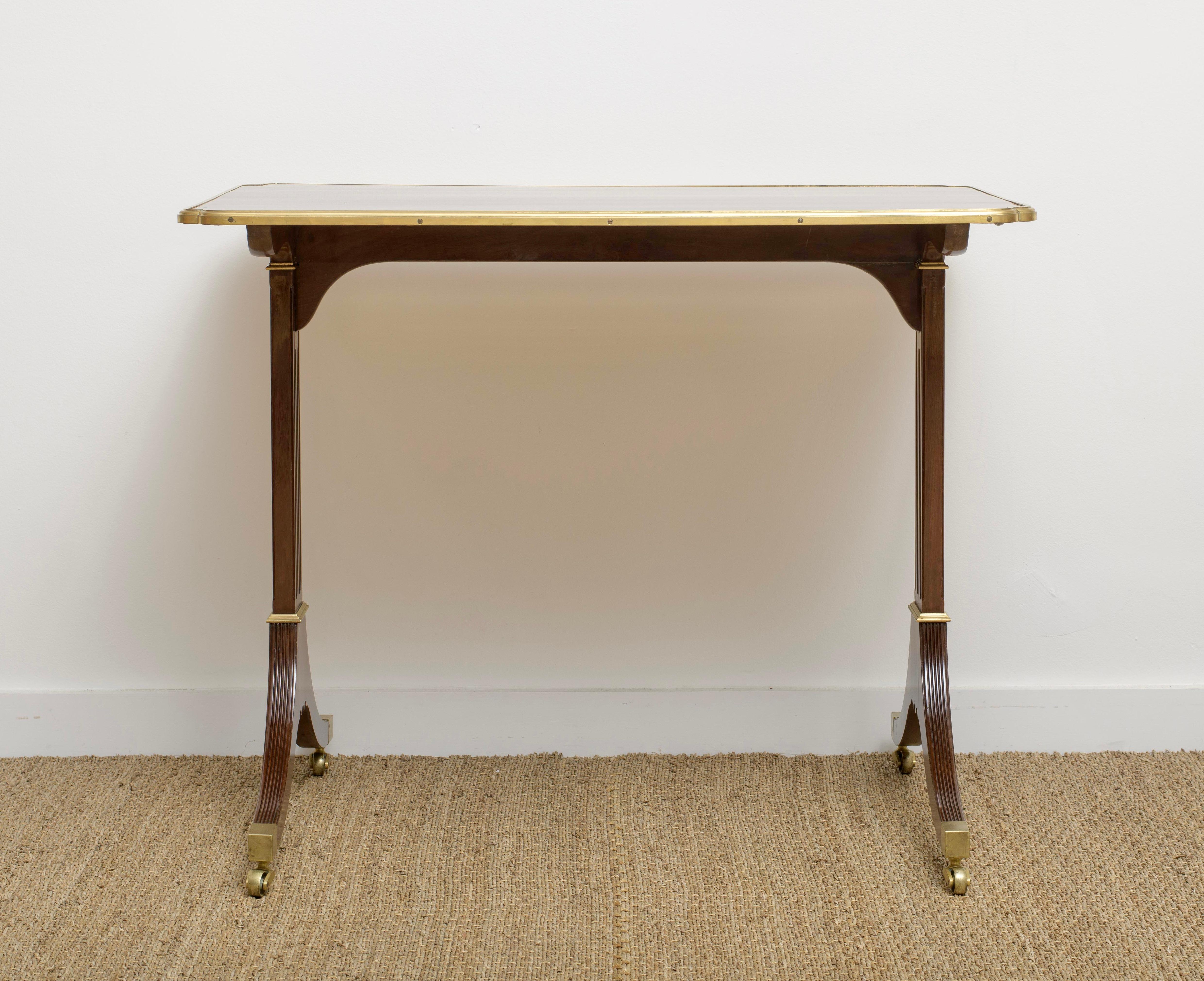 A Important Louis XVI period gilt-metal mounted mahogany occasional table, by Etienne Avril,
last quarter 18th century
The shaped rectangular top with rounded corners and moulded edge, above
channelled trestle supports terminating in splayed legs