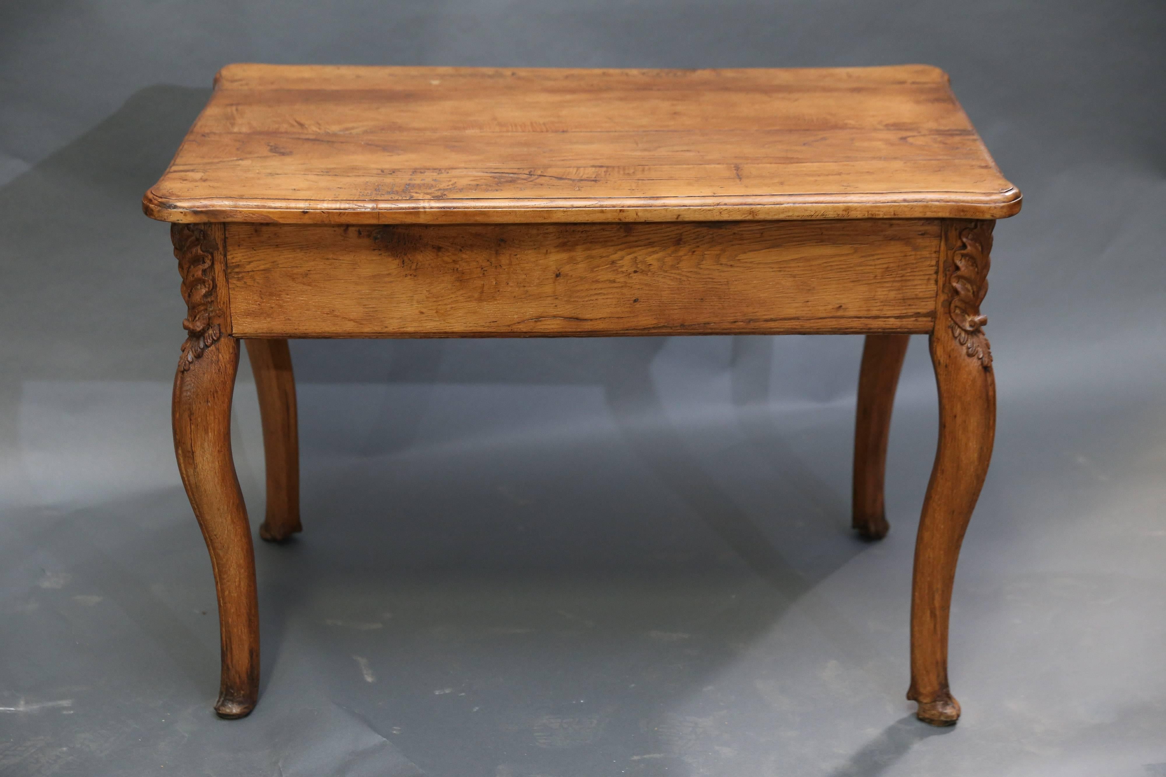 table Louis XIV du XVIIIe siècle à pied cabriole terminé par un pied sabot avec une belle sculpture de feuilles à chaque angle.