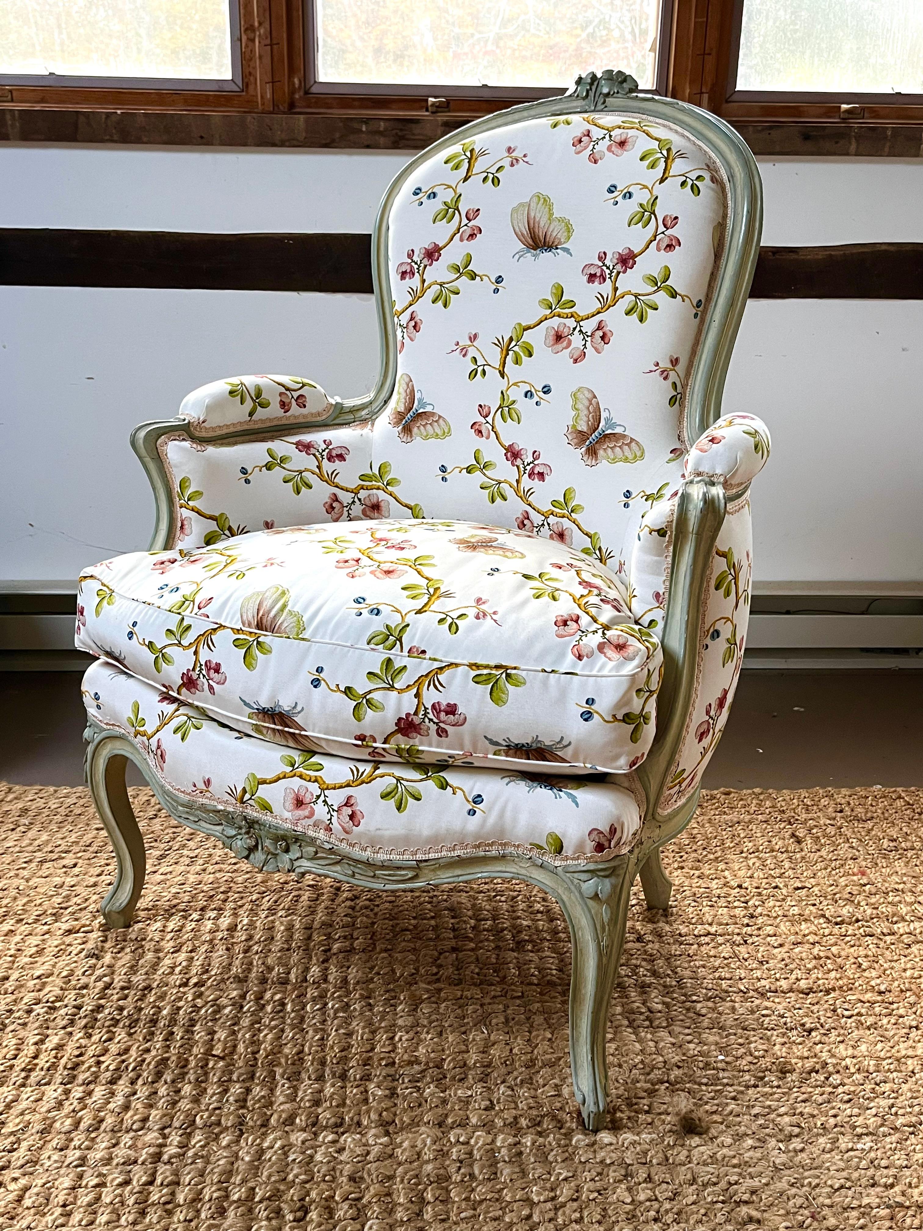 Bergère-Cabriolet aus der Zeit Ludwigs XV., blassgrün lackiert, mit geschnitzten Blumen und Ranken auf dem Kamm, der Sitzschiene und den Cabriole-Beinen. Derzeit mit dem Stoff 