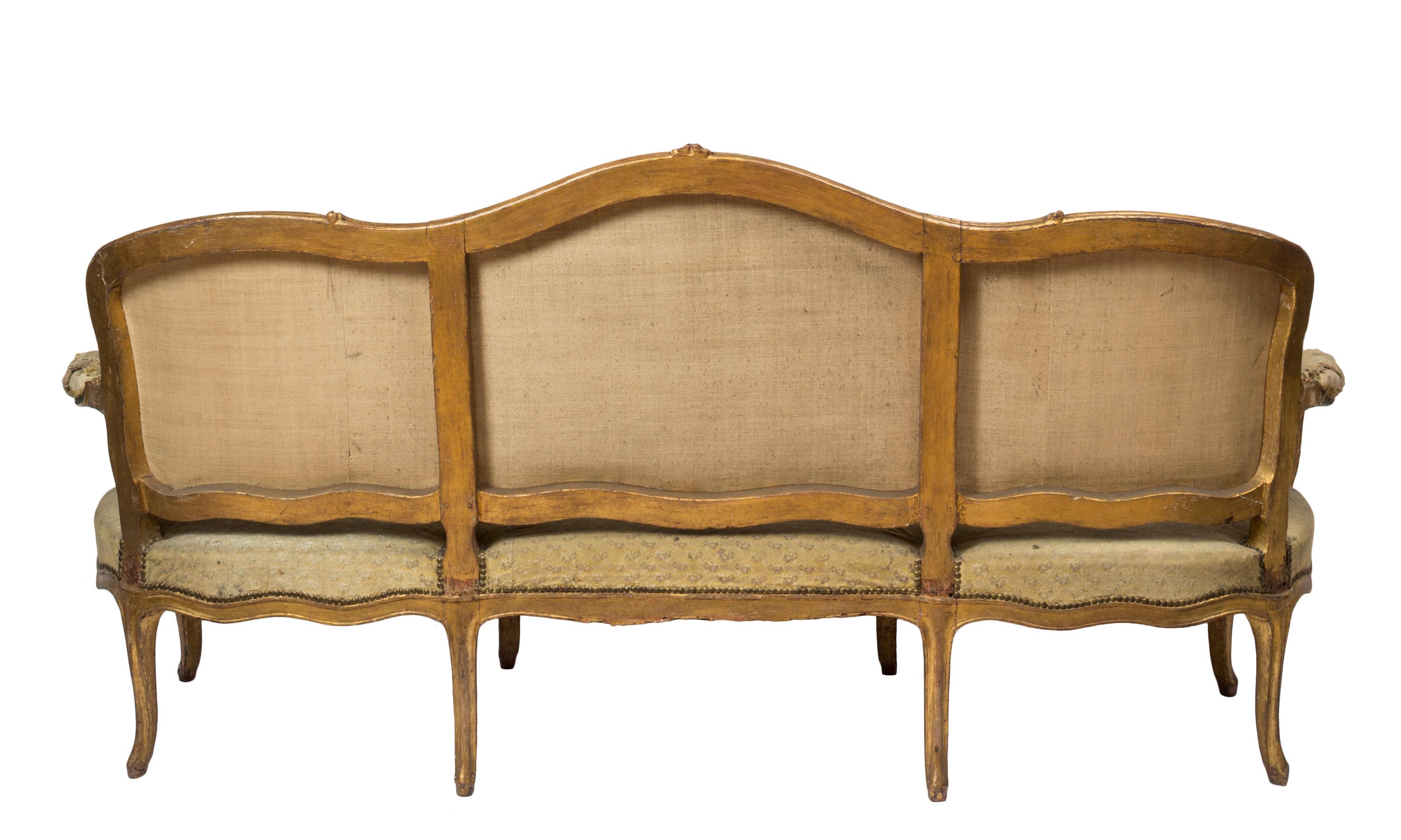 Three piece set, late 18th century French Louis XV canapé / sofa / settee with two matching armchairs. The sofa is able to accommodate three sitters. Unique and noteworthy, all three pieces of this set are upholstered in their original gold colored