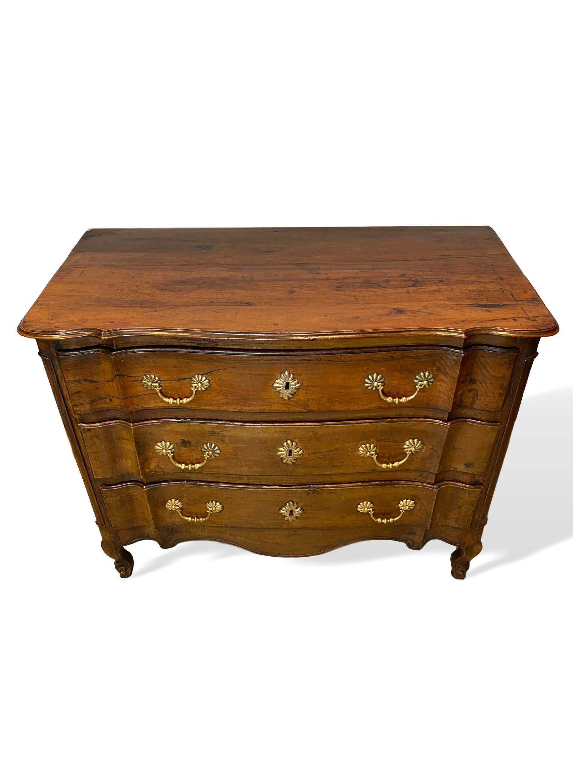 18th century Louis XV carved cherry commode, French, circa 1750, the rectangular top with molded edge and shaped conforming slight serpentine front edge, three shaped and lipped long drawers, relief carved paneled stiles, molded and paneled sides,