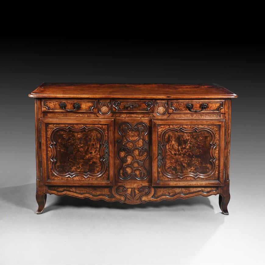 A fine quality provincial French Louis XV burr field ash and fruitwood carved buffet of excellent colour and patination from the Bresse region.

French Louis XV circa 1770.

The moulded top above a small scroll-moulded frieze drawer, flanked by