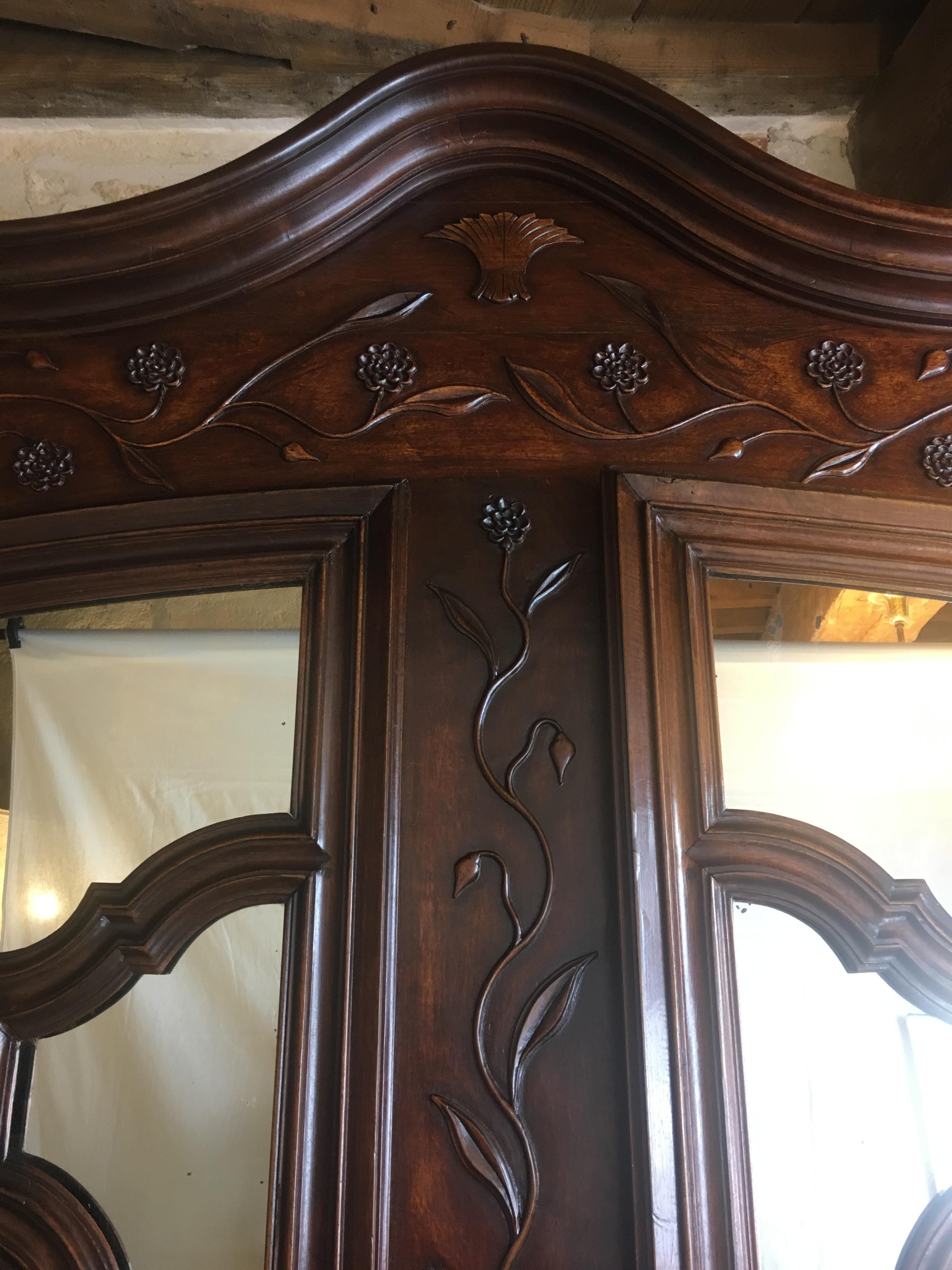 Magnificent 18th-century French armoire, a testament to Louis XV craftsmanship. This imposing walnut wardrobe showcases intricate carvings and a distinctive 