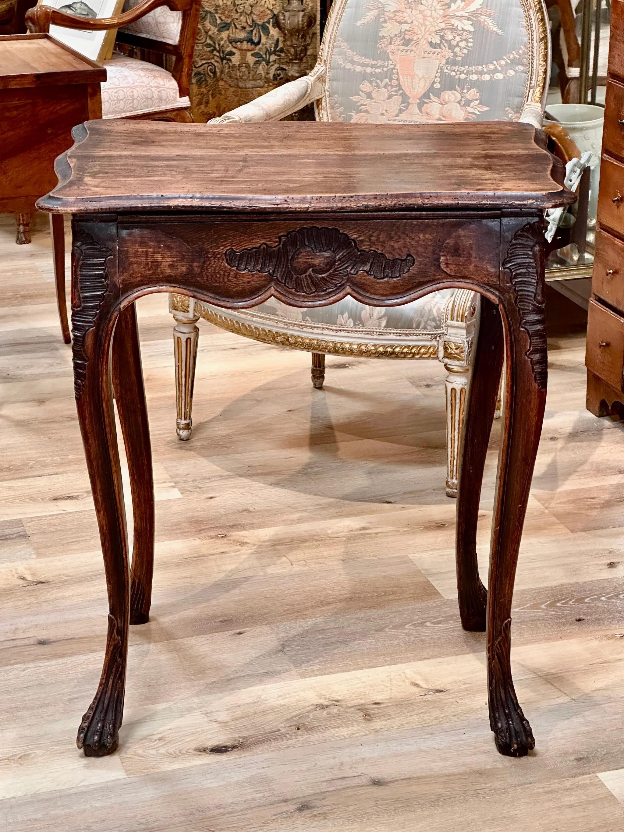 18th Century Louis XV French Provincial Side table, the figured rectangular top over finely carved skirt having elegant cabriole legs ending in beautiful claw feet on flattened balls.   H 31.5