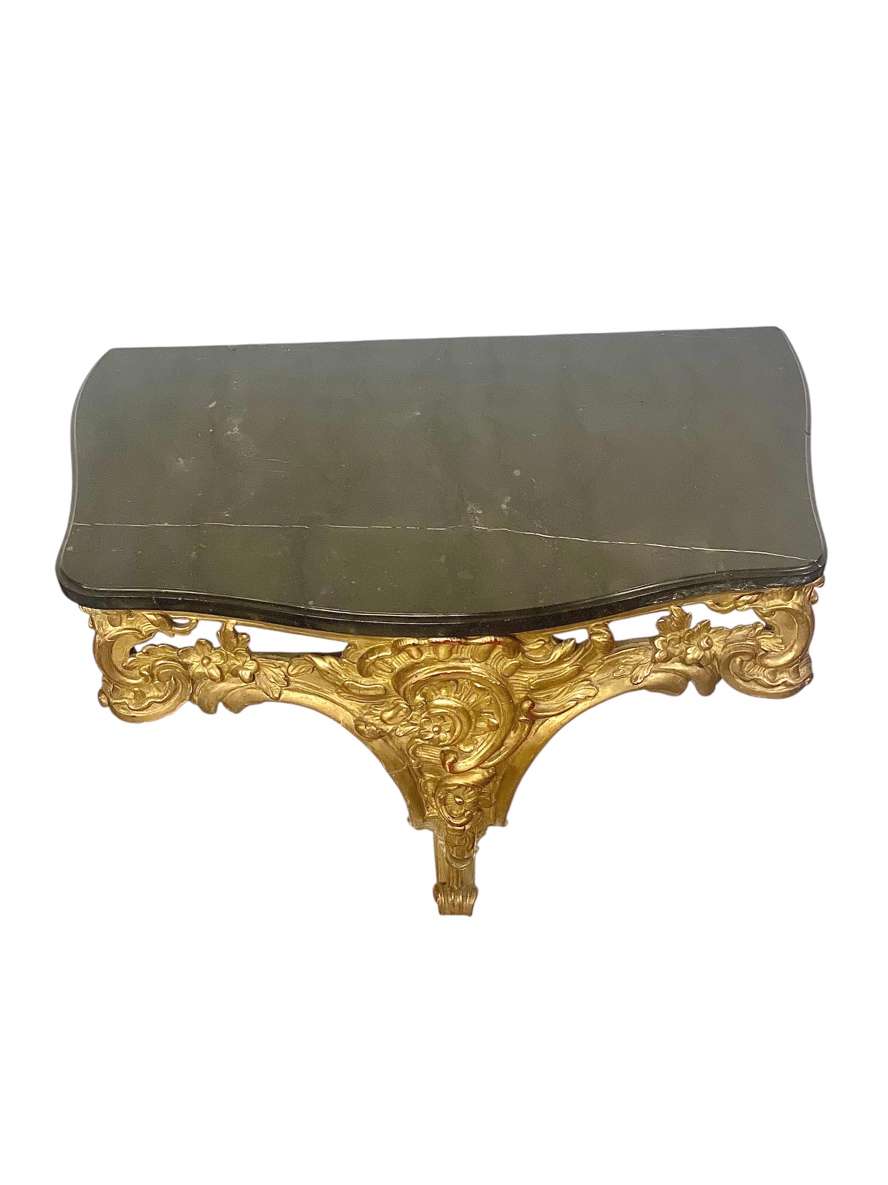 An exceptional 18th century French Louis XV giltwood wall console, hand-carved in richly detailed relief with exquisite Rococo motifs. This refined piece, created during the reign of King Louis XV, showcases the elegance and movement typical of the