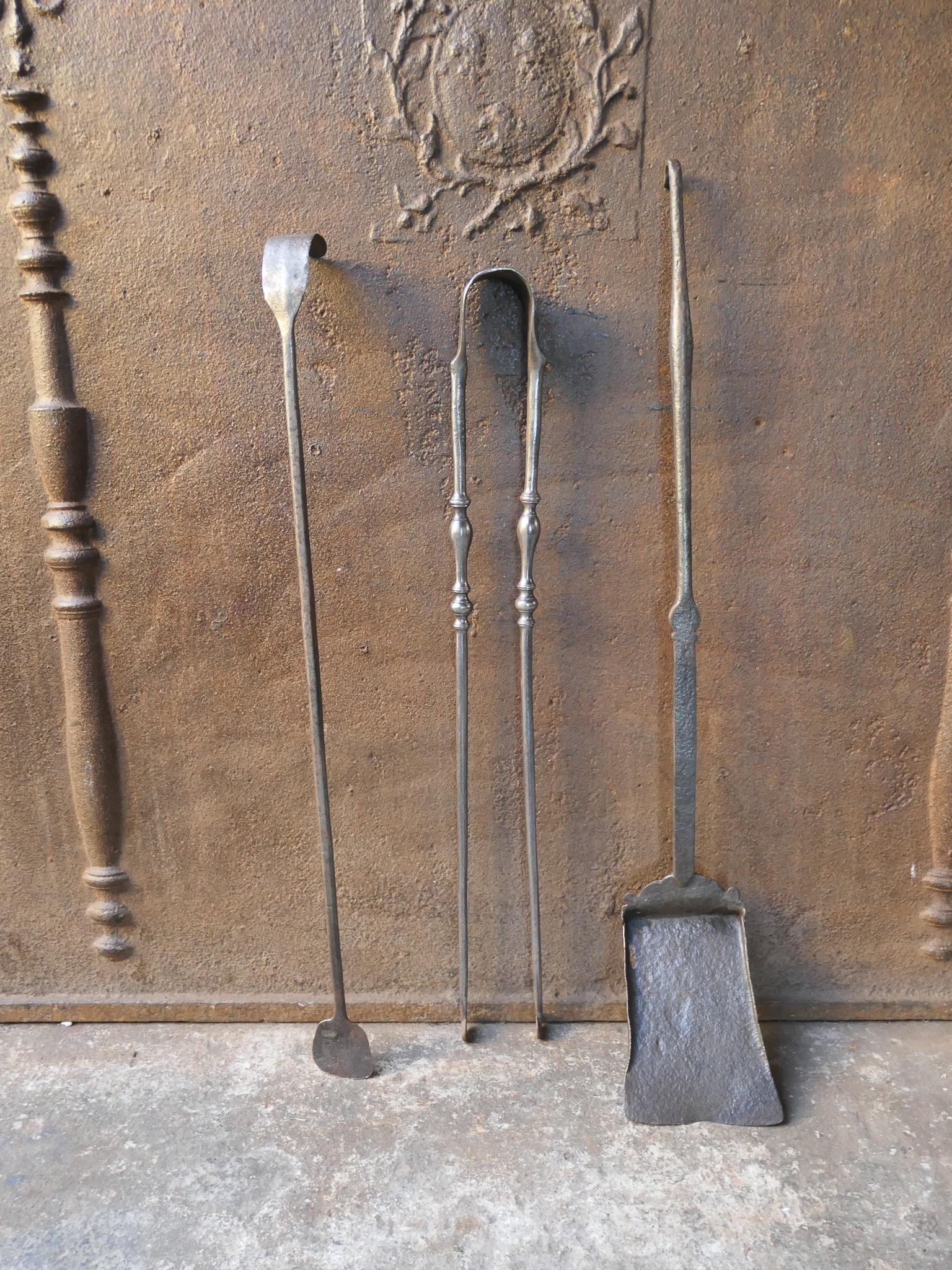 Ensemble de compagnons de cheminée d'époque Louis XV, datant du 18e siècle. Le jeu d'outils comprend une pince, une pelle et un tisonnier. Fabriqué en fer forgé. Il est en bon état et fonctionne parfaitement.
