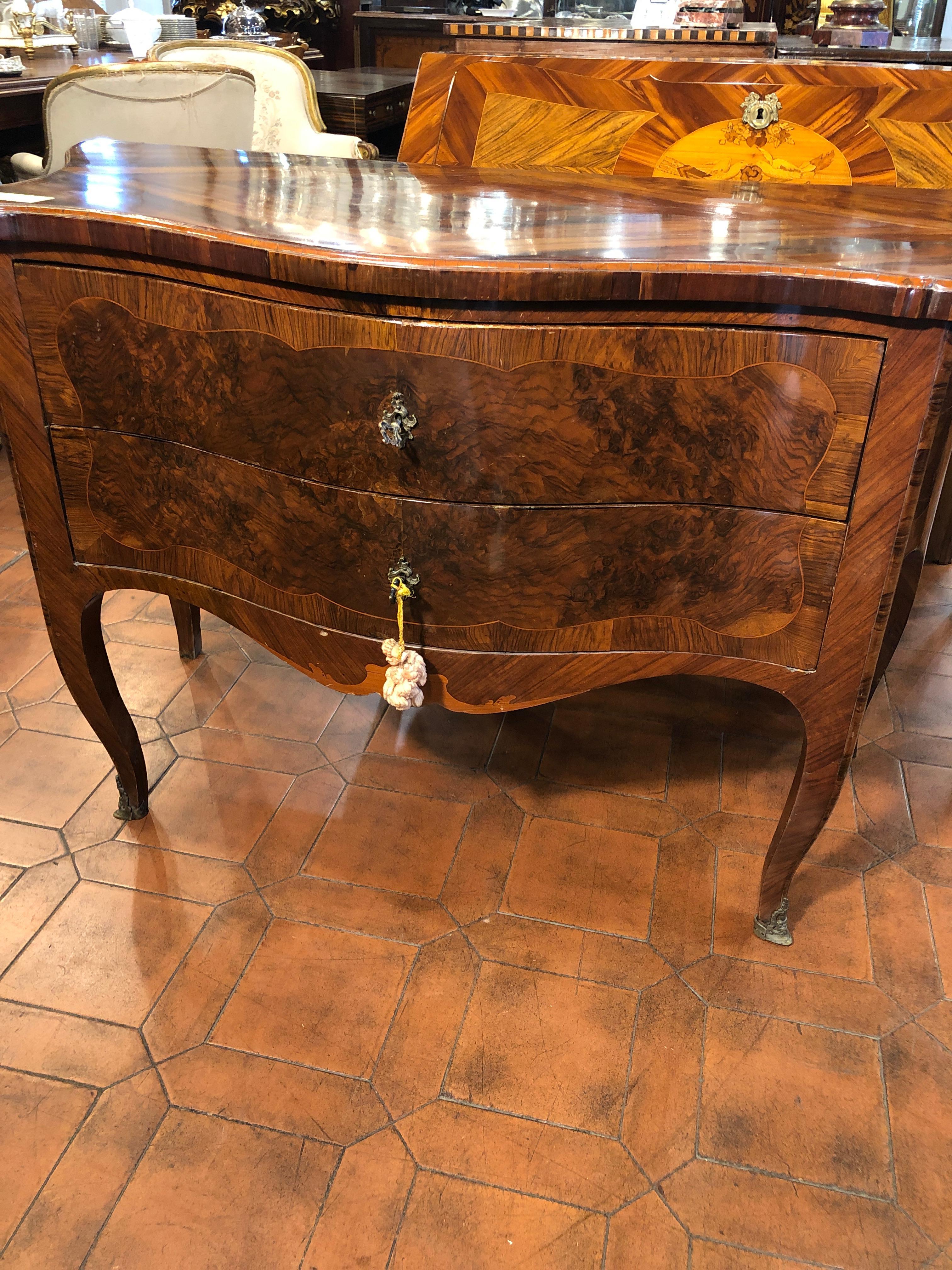 Italian chest of drawers of Roman origin, moved with a crossbow, rare in its construction and in its shapes, it highlights the quality in the choice of woods and in the use of essences. Period around 1730, full period Louis XV, in walnut and olive.