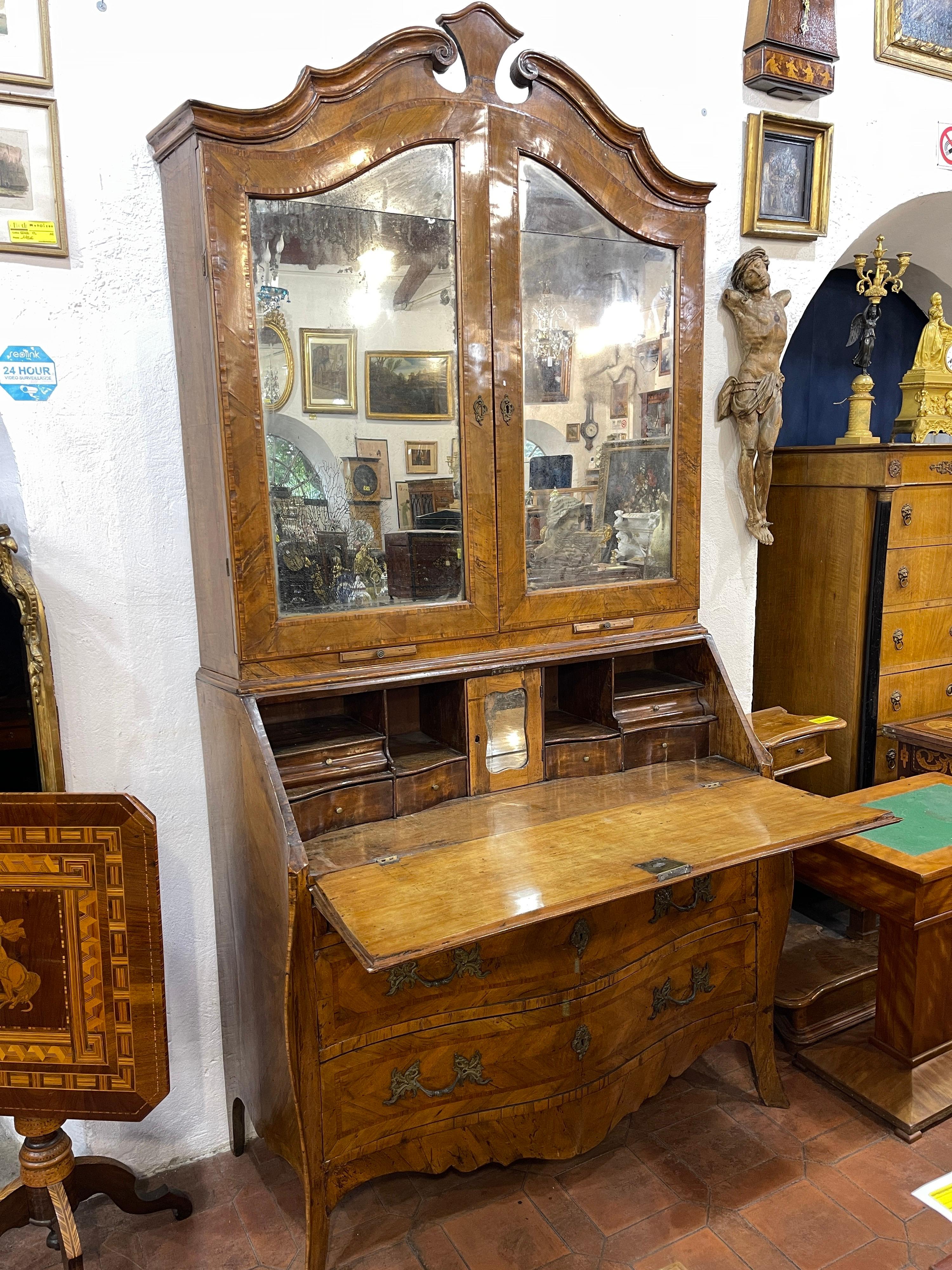 Trumeau with walnut paneling and bois de rose stitching, two upper mirrored doors, two small drawers, chest with seven drawers inside, four open compartments and one door, four lower drawers, moved front. Genoa, 18th century. (defects)
Secretaire