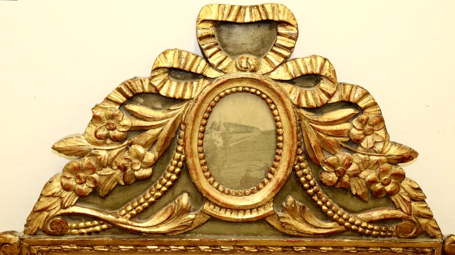 18th century Louis XV wall mirror with an oval etching / print of a European scene and ribbon bow and flower designs. Wonderful color with a rich mellow patina.