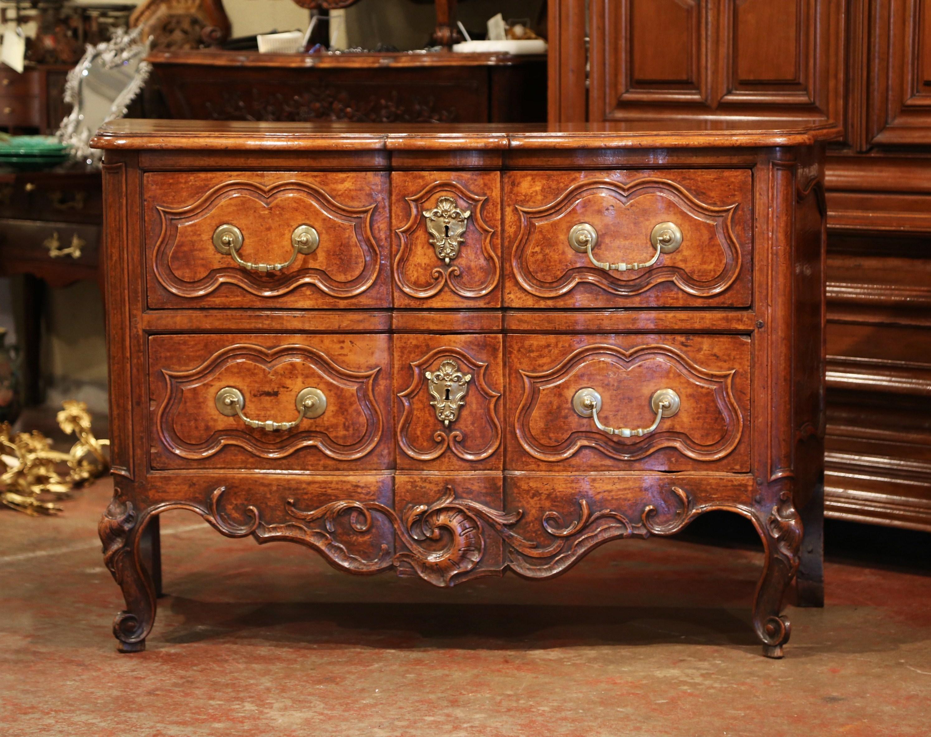 This important antique fruitwood commode was crafted in Southern France, during the reign of King Louis XV, circa 1745-1749, which was determined by its tax stamp. The elegant chest with curved sides, features a serpentine moulded front with two