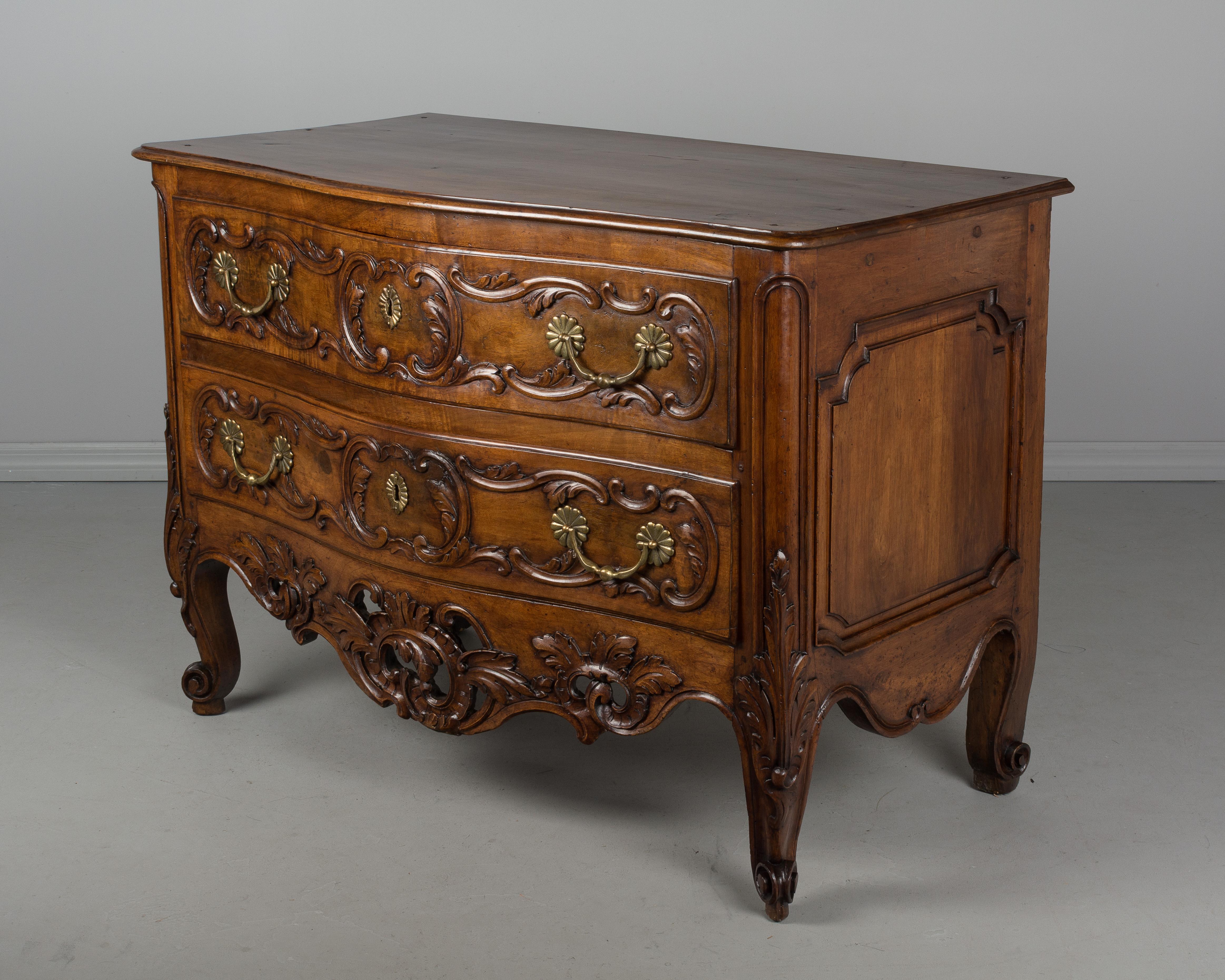 A fine 18th century Louis XV period commode from the town of Nîmes in Provence. Made of solid walnut with serpentine front and raised panels on the sides. Pegged construction with waxed finish. Beautiful hand-carved foliate decoration including an
