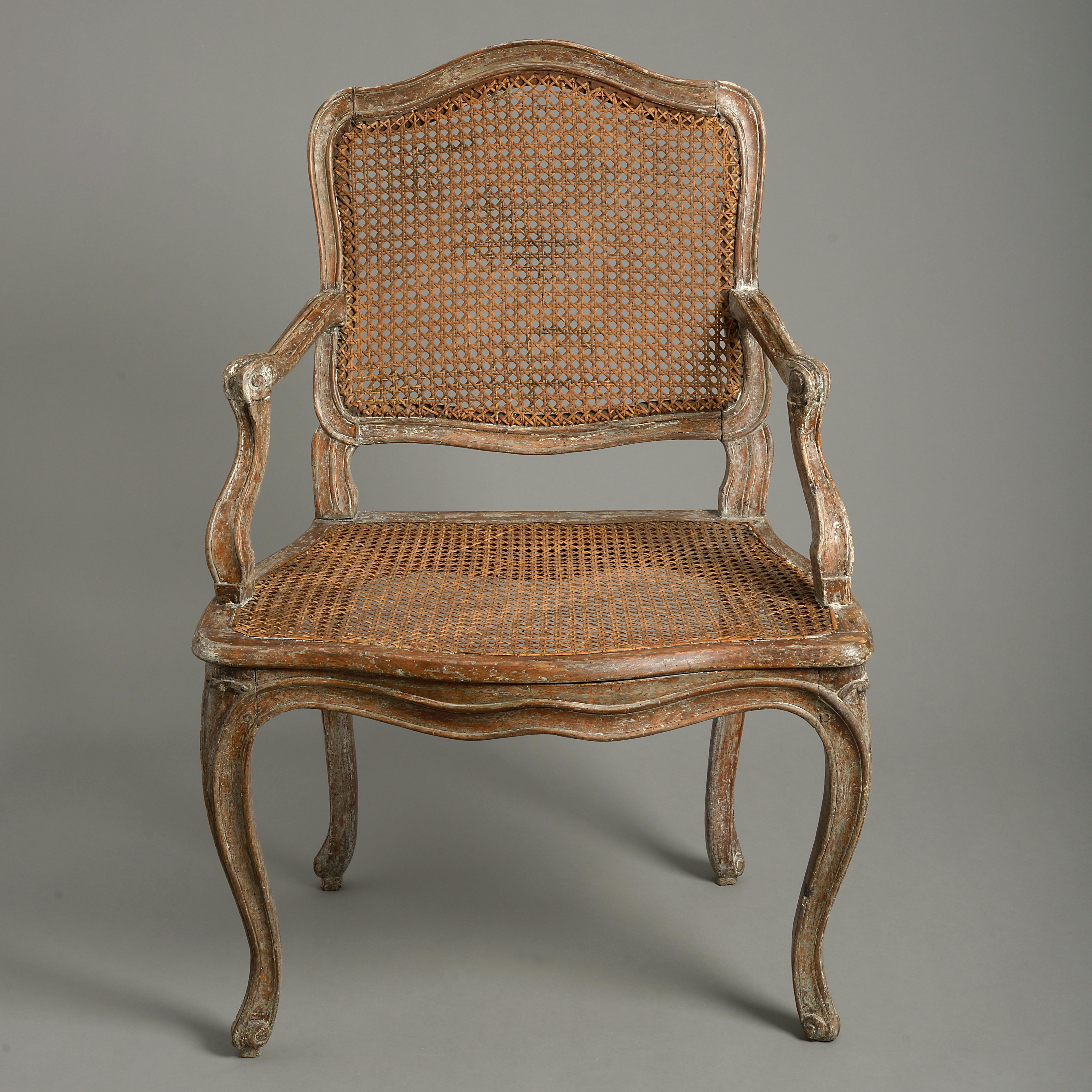 A mid-18th century Louis XV Period painted fauteuil or open armchair, the cartouche back and seat with caning, having scrolling arms and raised upon cabriole legs.

 