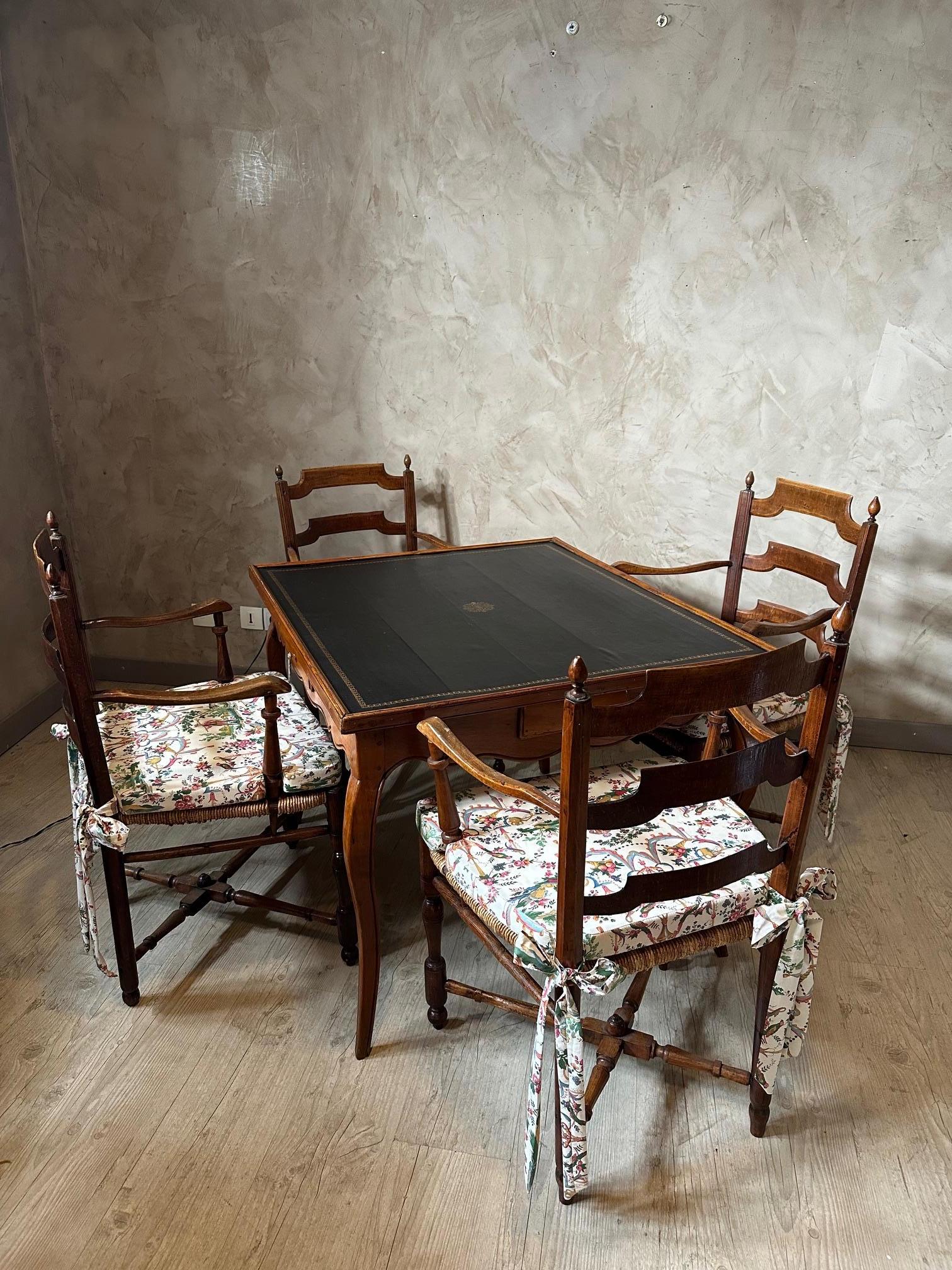 Schönes Set aus einem Spielkartentisch mit vier Stühlen aus der Zeit Ludwigs XV. 
Der Tisch hat auf jeder Seite eine Schublade mit Messinggriff. Die Oberseite ist mit schwarzem Leder bezogen. 
Jeder Stuhl hat ein Kissen, das mit einem schönen Pierre