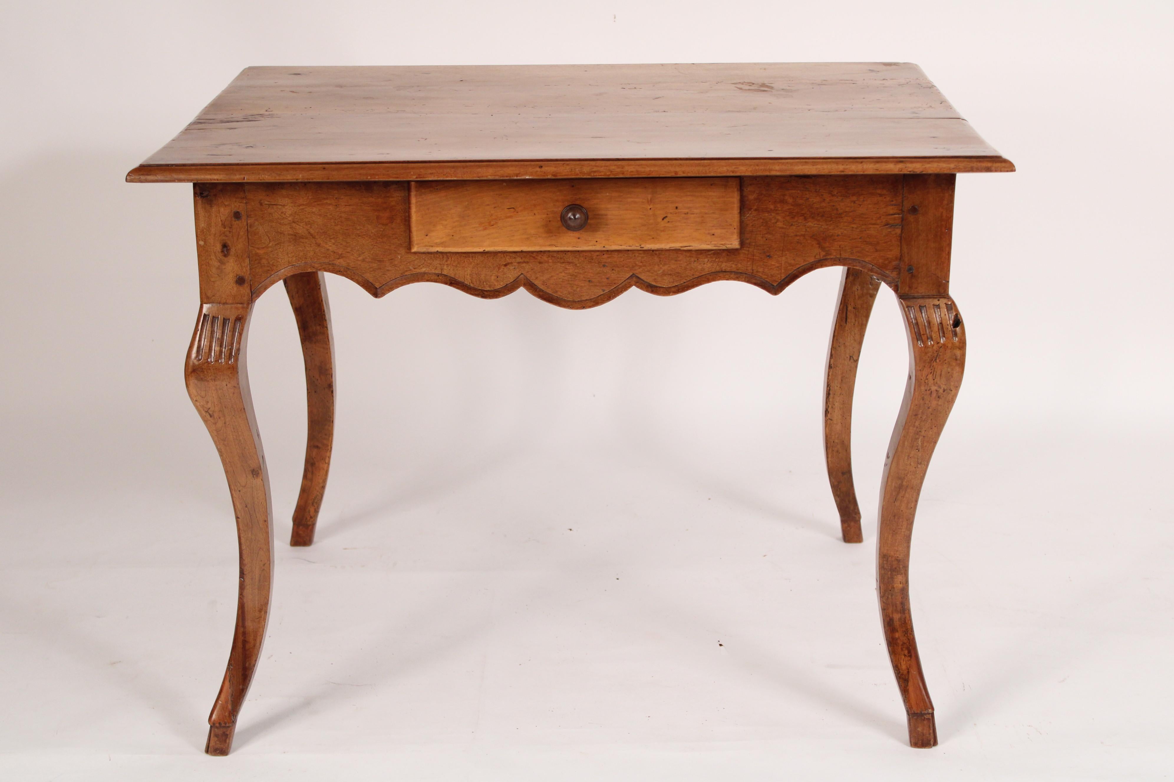 Table d'écriture / d'appoint en noyer de style Louis XV, XVIIIe siècle. Le plateau en porte-à-faux est composé de trois planches avec des bordures moulurées, une frise avec un tiroir et un tablier festonné, le tout reposant sur des pieds cabriole.