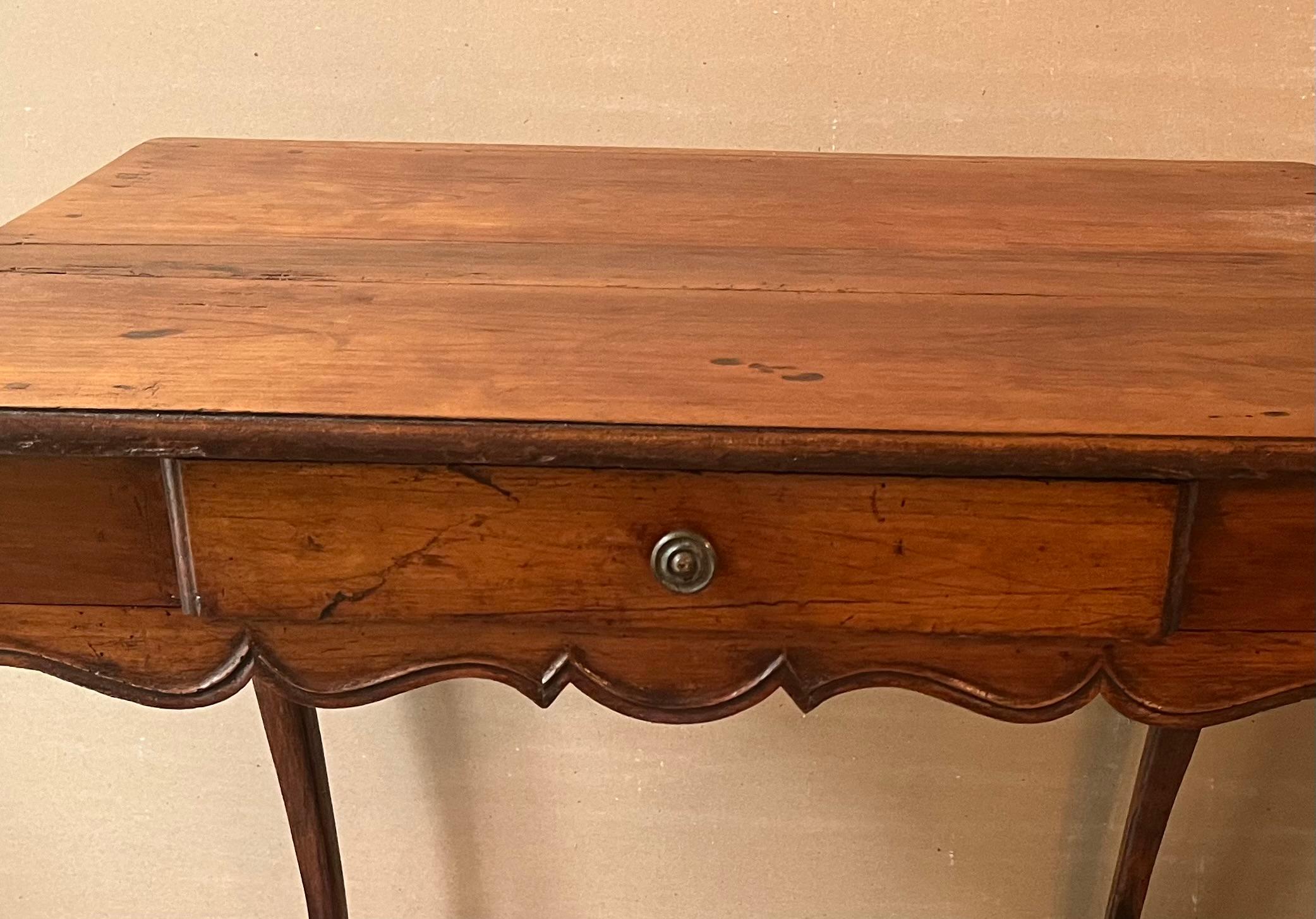 Table à écrire en noyer, d'époque Louis XV, vers 1770. Le plateau d'origine est conforme à la norme et repose sur un tablier festonné avec un tiroir, sur des pieds en cabriole. Finition ancienne, belle patine. 