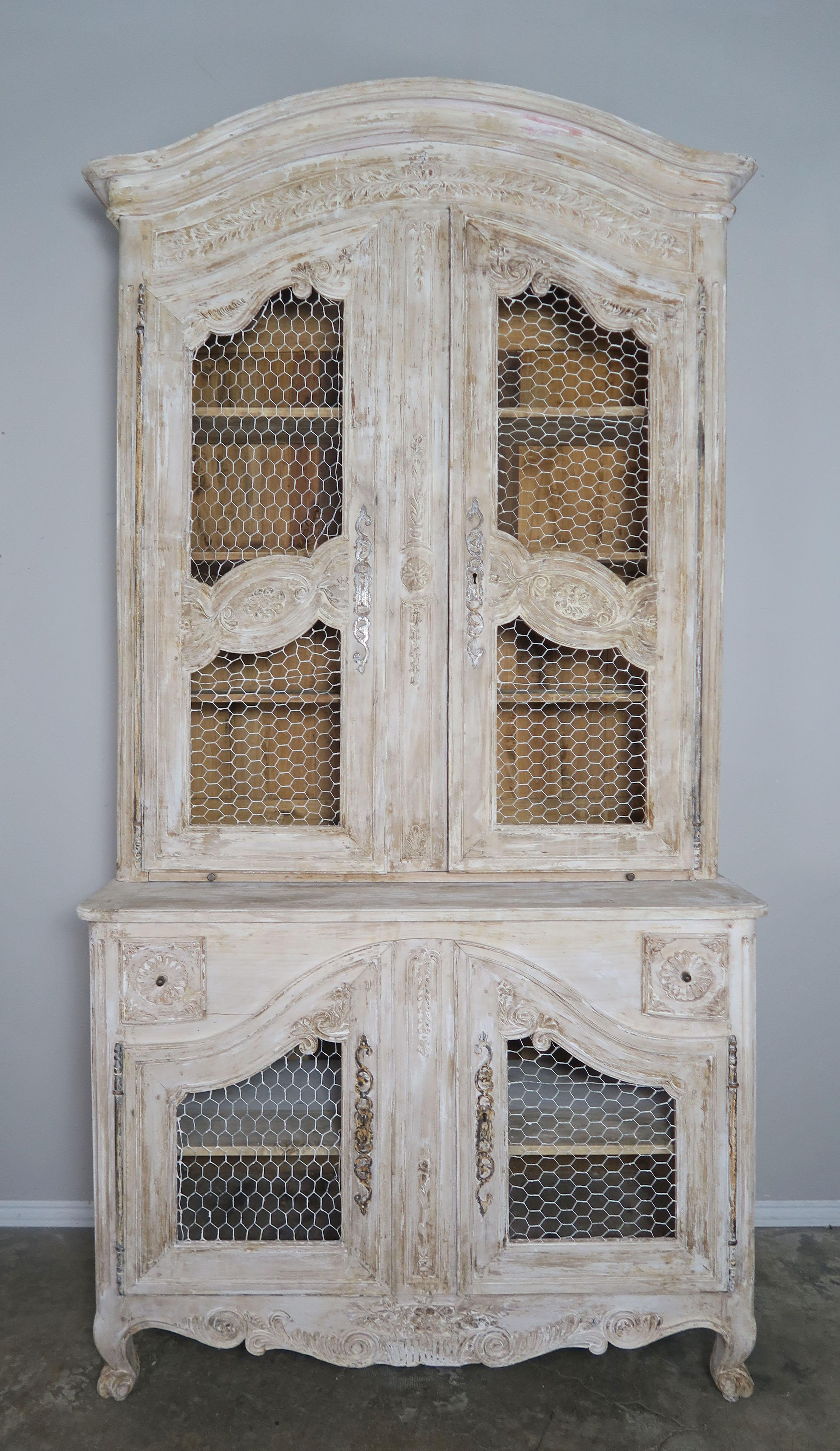 18th century painted Louis XV style buffet de corps with chicken wire. The stunning cabinet stands on four cabriole legs. Four separate doors open up to shelves with ample storage inside. There are two accent drawers as well. Worn paint with wood