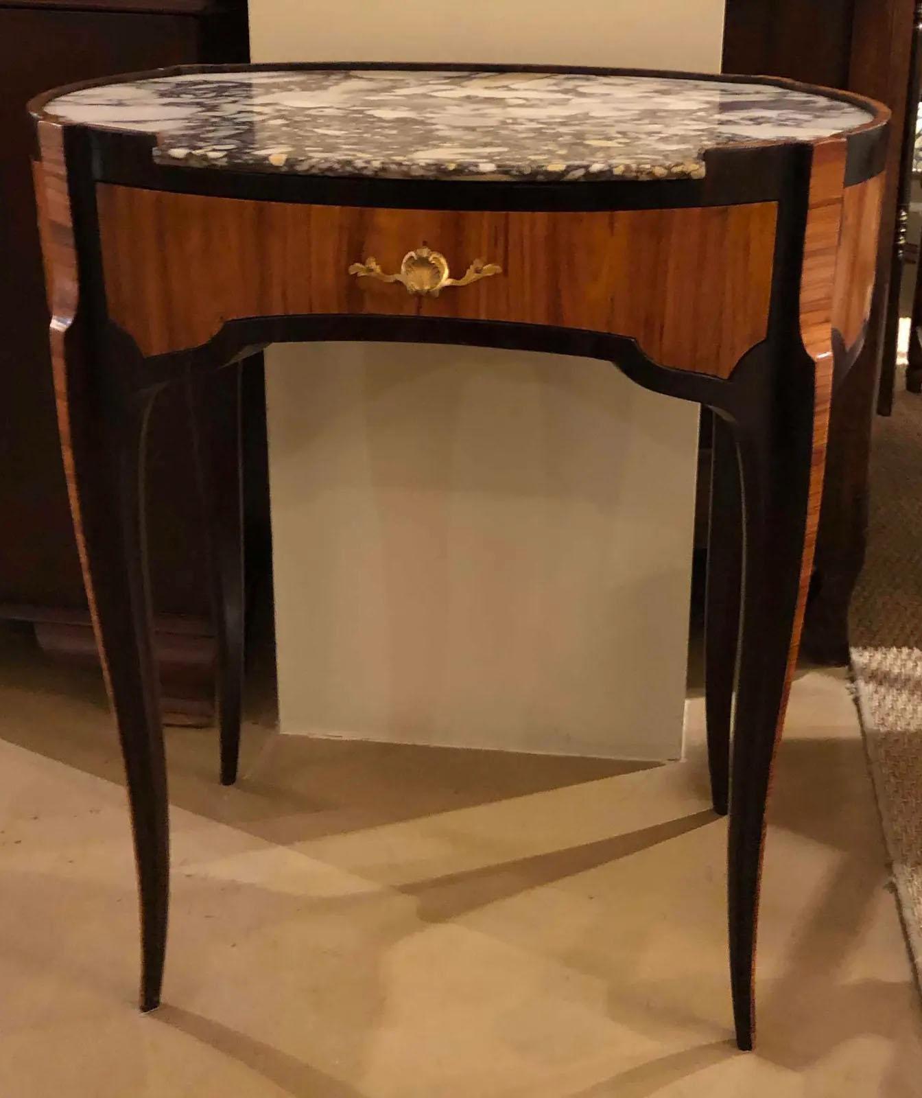 An oval shape 18th century Louis XV table with marble top. Features green striped interior of drawer. French, circa 1780-1800.