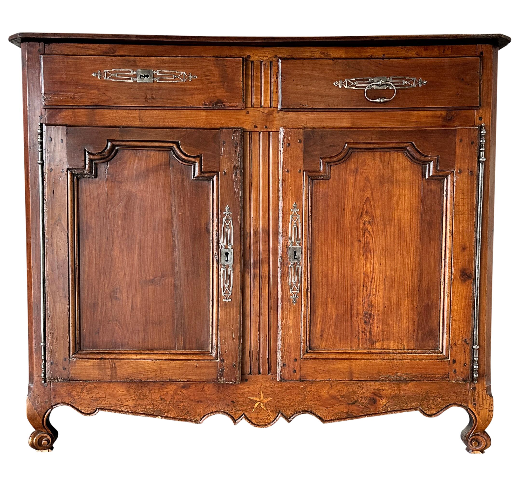 Buffet francese di qualità del XVIII secolo in noce intagliato a 2 cassetti e 2 ante con ferramenta in acciaio e stella intarsiata sul grembiule inferiore.
Durante il regno di Luigi XV, nel 1700, i menuisier francesi erano abili lavoratori del legno