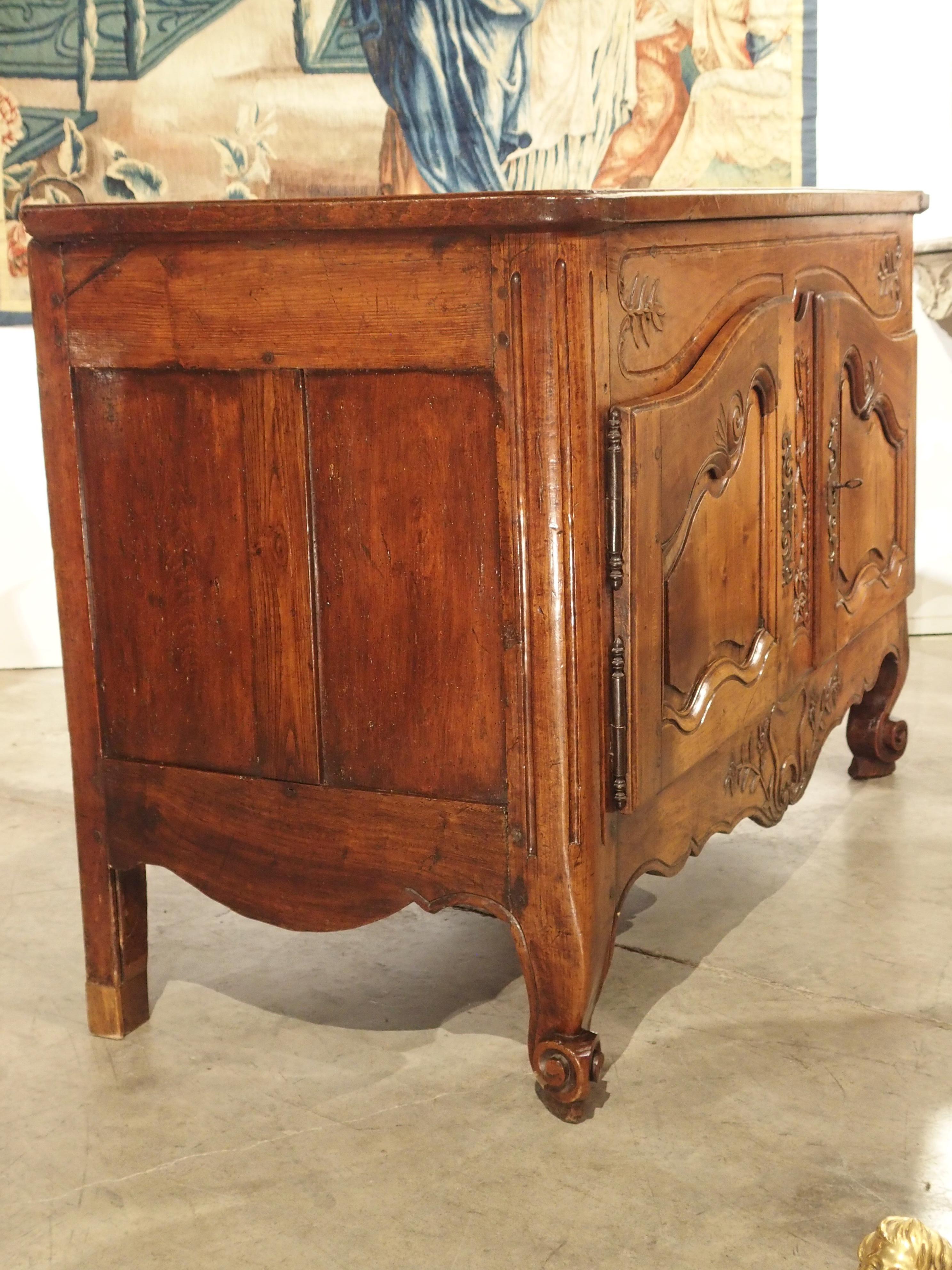 This charming walnut wood buffet was constructed for a family living in Provence in the 1700s. Before the mid-1800s, regional French furniture was always commissioned by skilled ebenists or wood workers. This buffet has ornamentation of stalks of