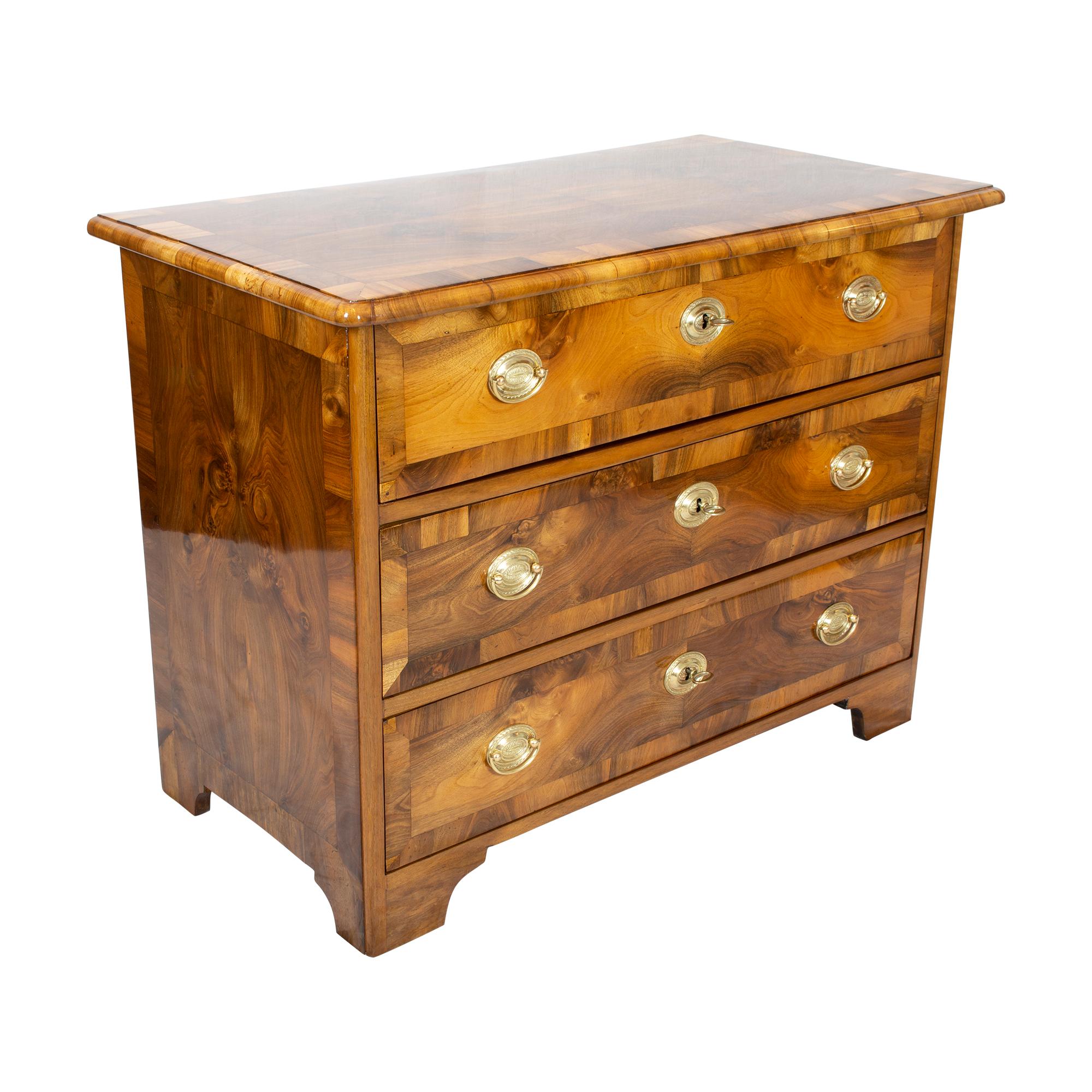 An 18th century Louis XVI marquetry commode with three drawers from West Germany. Thick walnut veneer sawn with frame in walnut on a spruce wood corpus. All keys, fittings are made of brass, the locks are from the time. It is a beautiful piece of