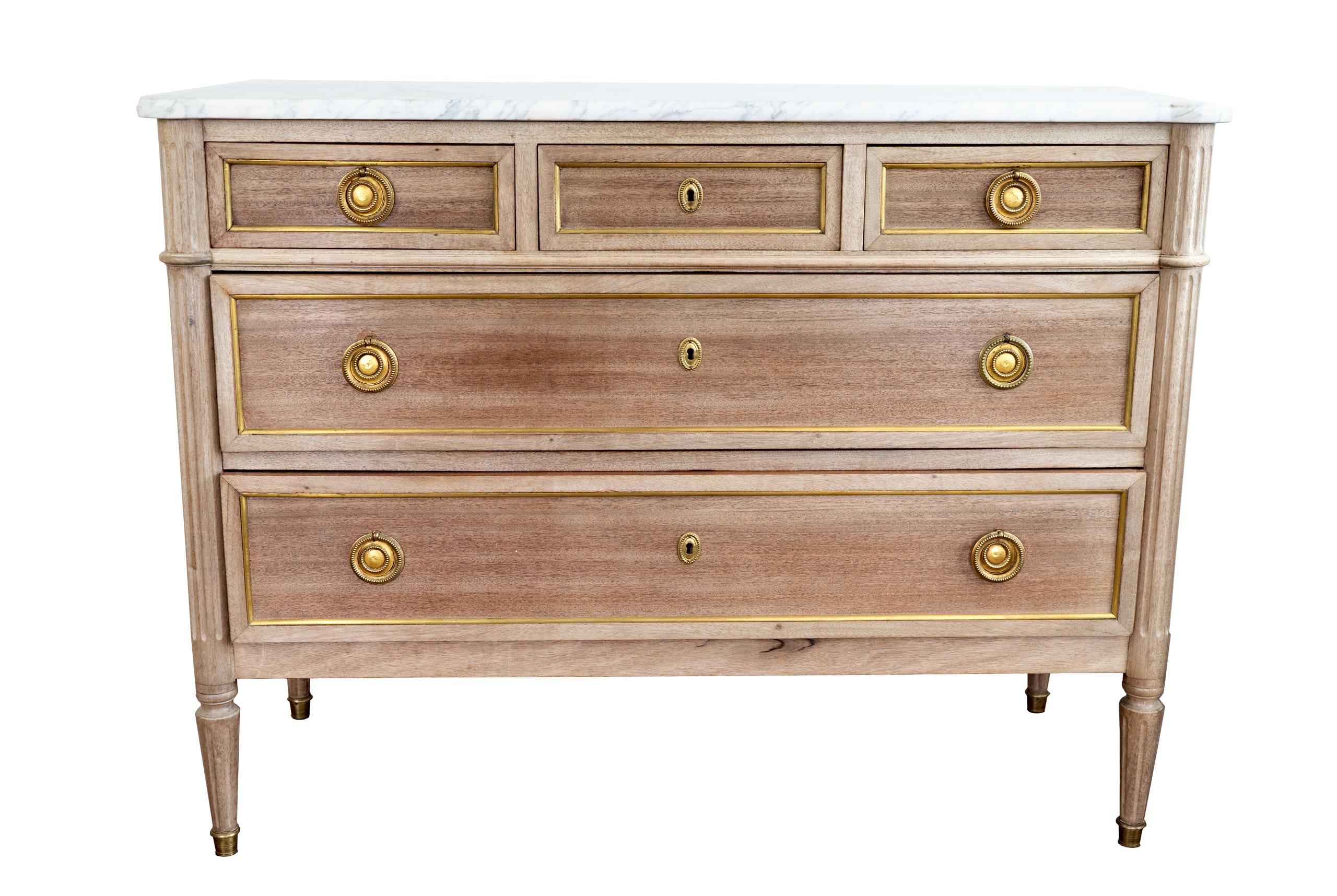 Beautiful five-drawer commode Louis XVI style chest with a white Carrara marble top and brass pulls. Bleached finish. The chest sits tapered fluted legs with fine detailing.