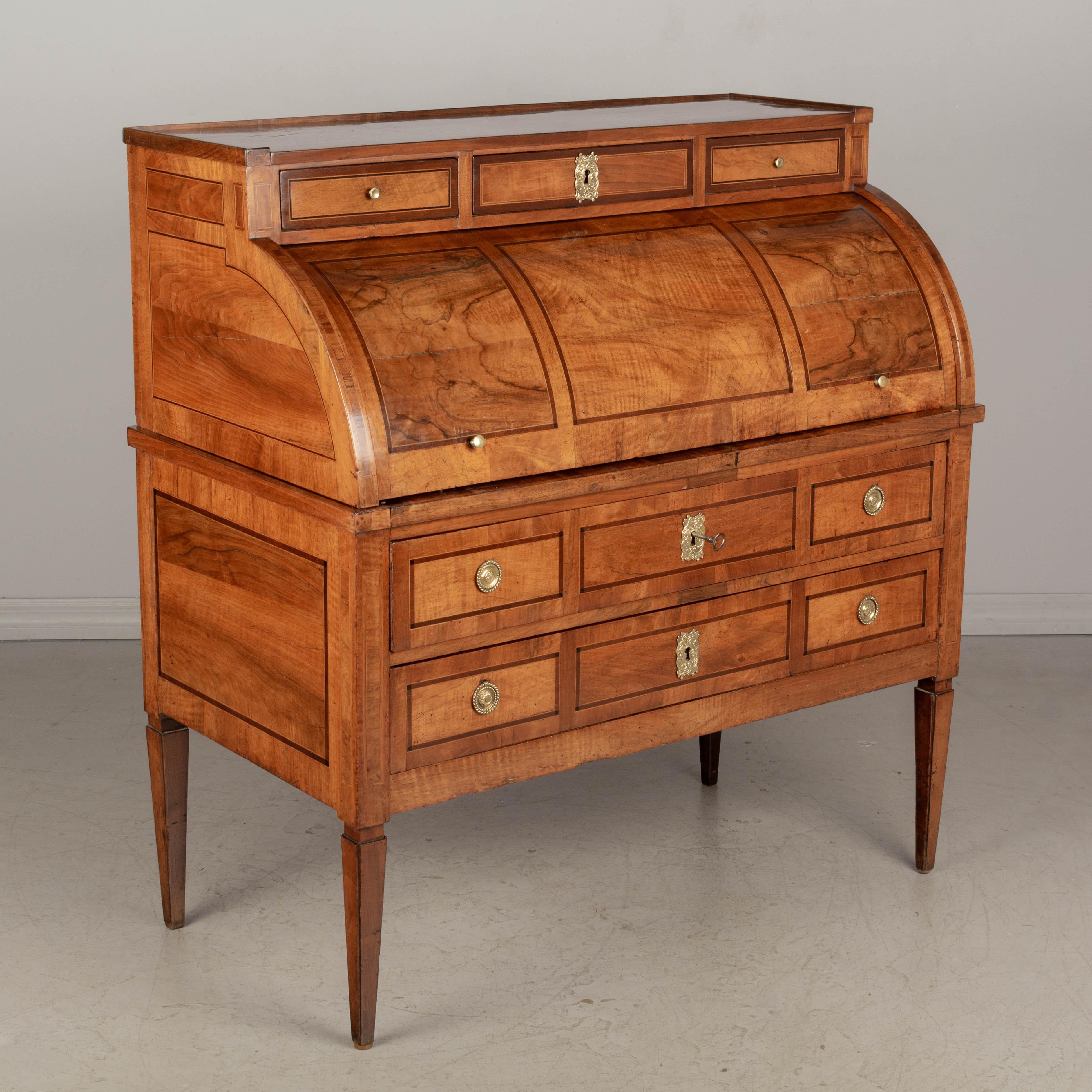 A fine 18th century Louis XVI period bureau à cylindre, or roll top desk, made of solid walnut with marquetry veneers of walnut, mahogany and cherry. Pine as a secondary wood. The surface of the cylinder has bookmatched walnut veneer and retains a
