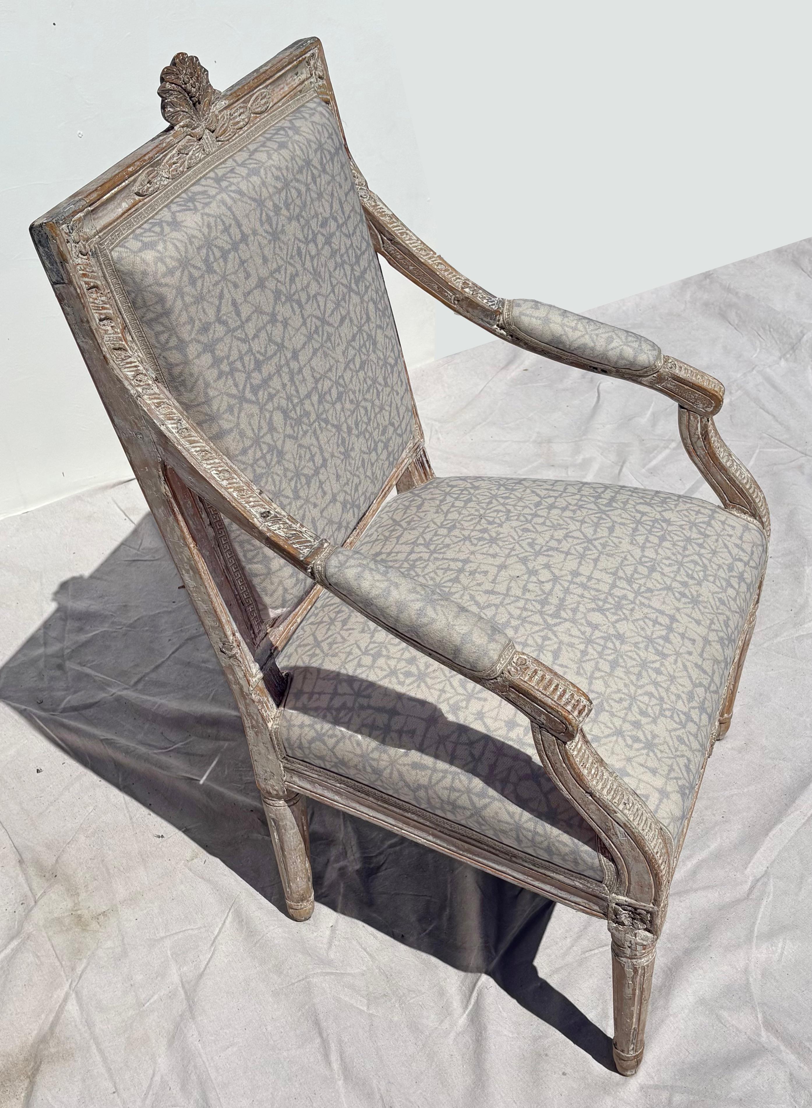 An unusual c.1780 Louis XVI rectangular back bergere in old oyster white paint with a delicious scraped and worn surface.  The carving of a bouquet at the crest rail is a nice feature. 