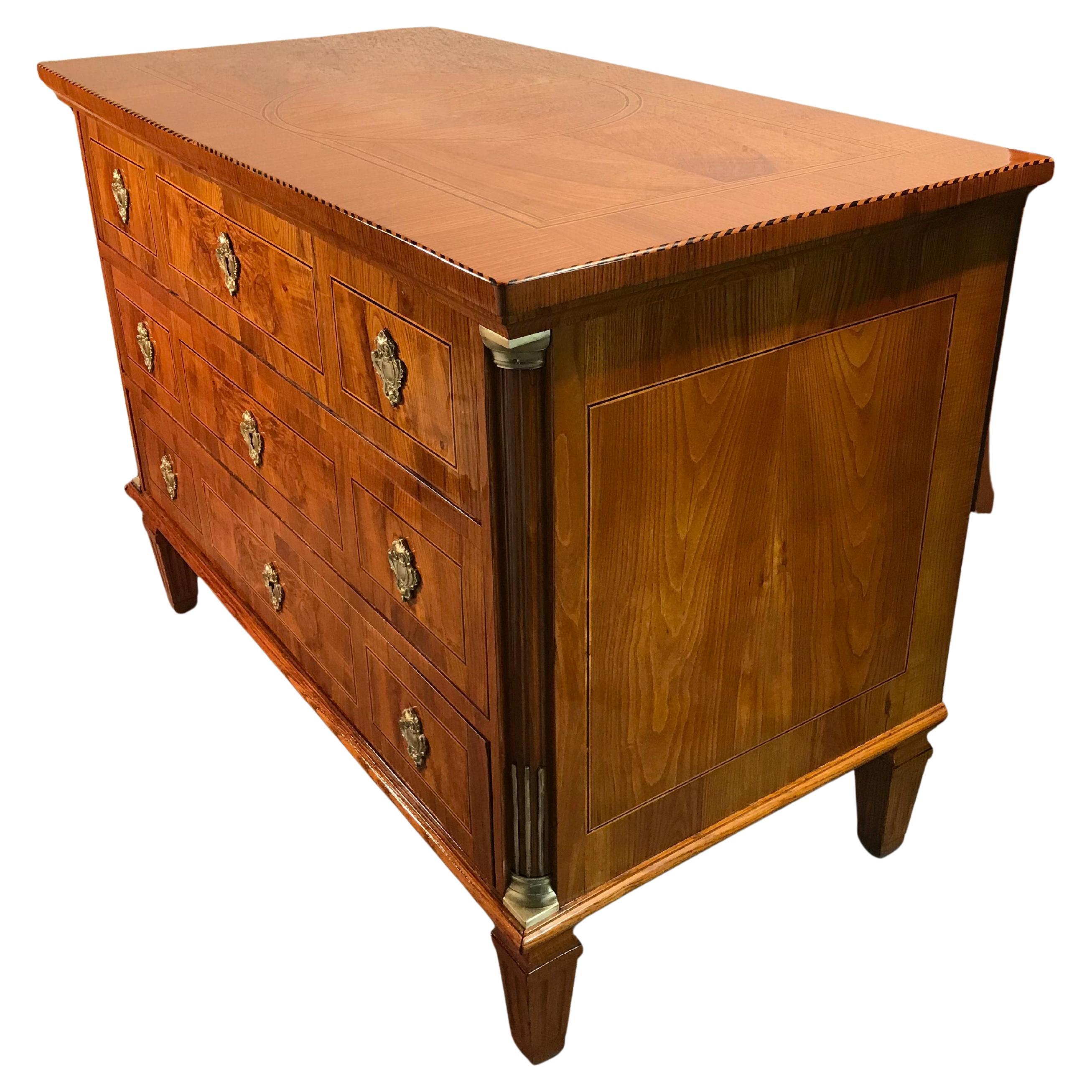 Diese außergewöhnliche Louis-XVI-Kommode aus dem 18. Jahrhundert, die um 1780 in Deutschland hergestellt wurde, ist ein beeindruckendes Beispiel für neoklassizistisches Design. Mit seinem exquisiten Kirschbaum- und Ulmenholzfurnier vereint dieses
