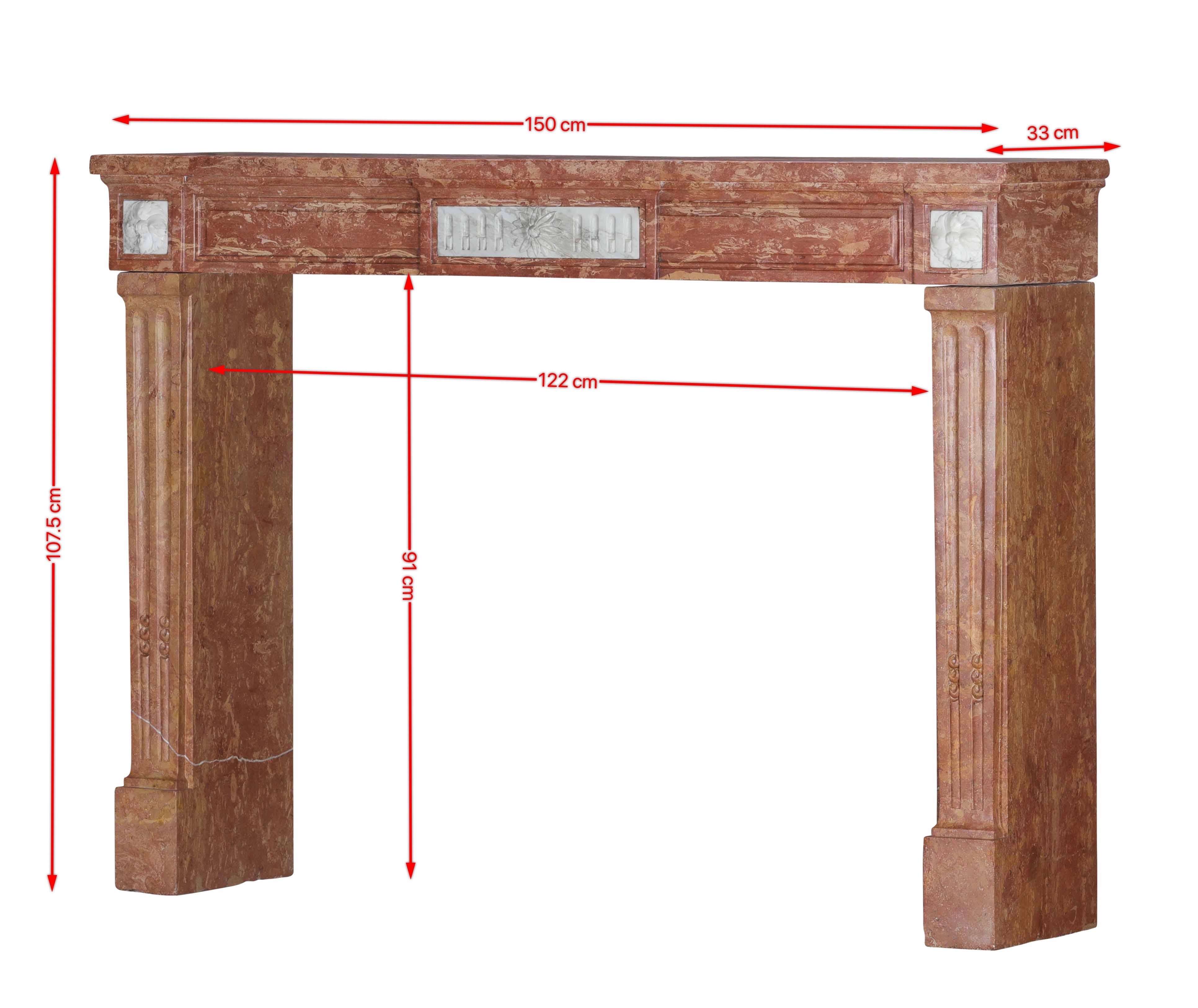 Questo straordinario caminetto del XVIII secolo Luigi XVI è un esempio eccezionale di raffinato artigianato francese, scolpito da tre blocchi massicci di pietra rosa di Borgogna e arricchito da eleganti inserti in marmo bianco statuario. Un raro