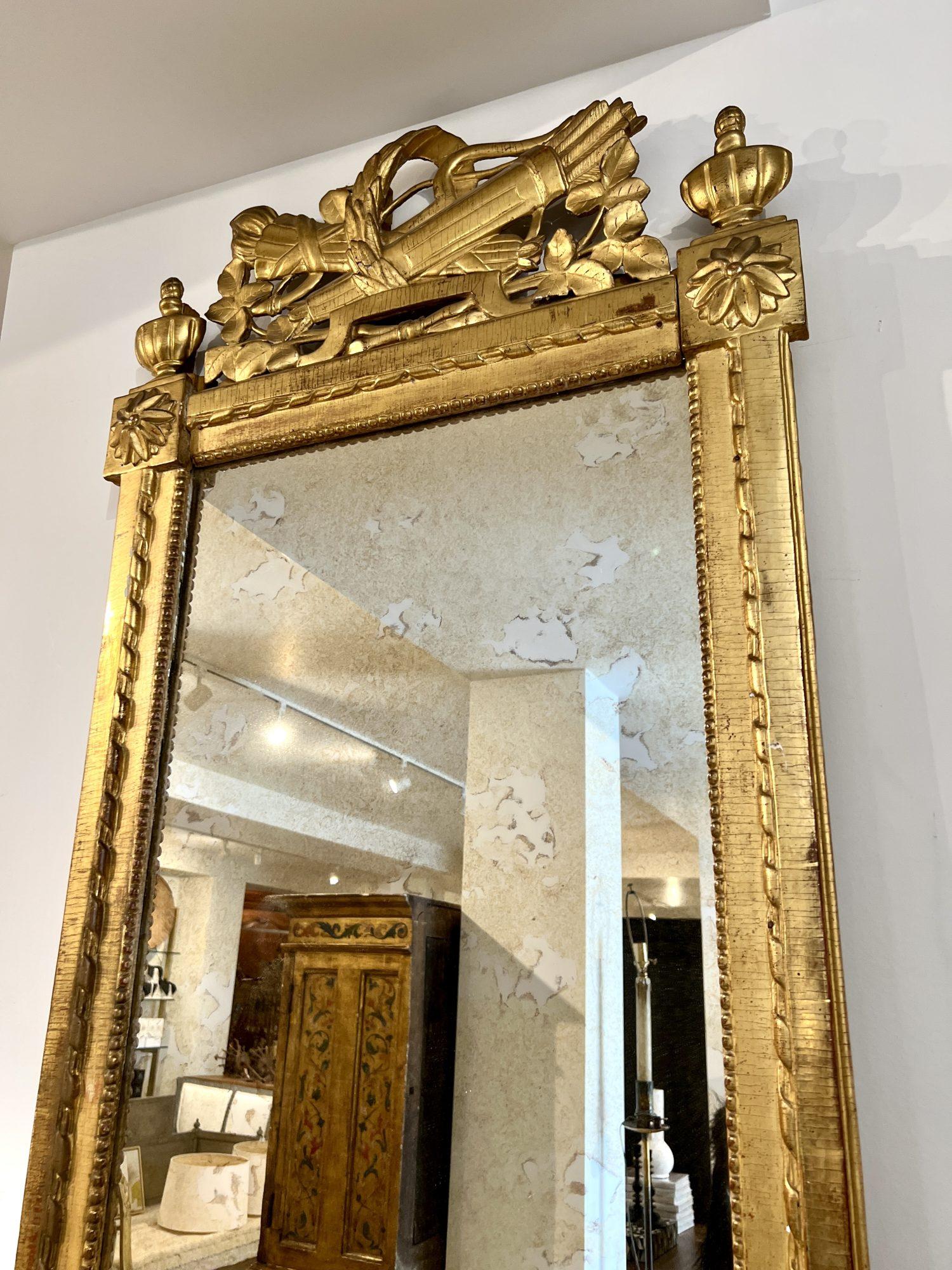 Miroir doré Louis XVI du XVIIIe siècle - Un reflet étonnant de l'élégance néoclassique, avec un cadre magnifiquement sculpté de motifs floraux complexes, de feuilles d'acanthe et d'une finition raffinée et dorée. Les lignes épurées et
